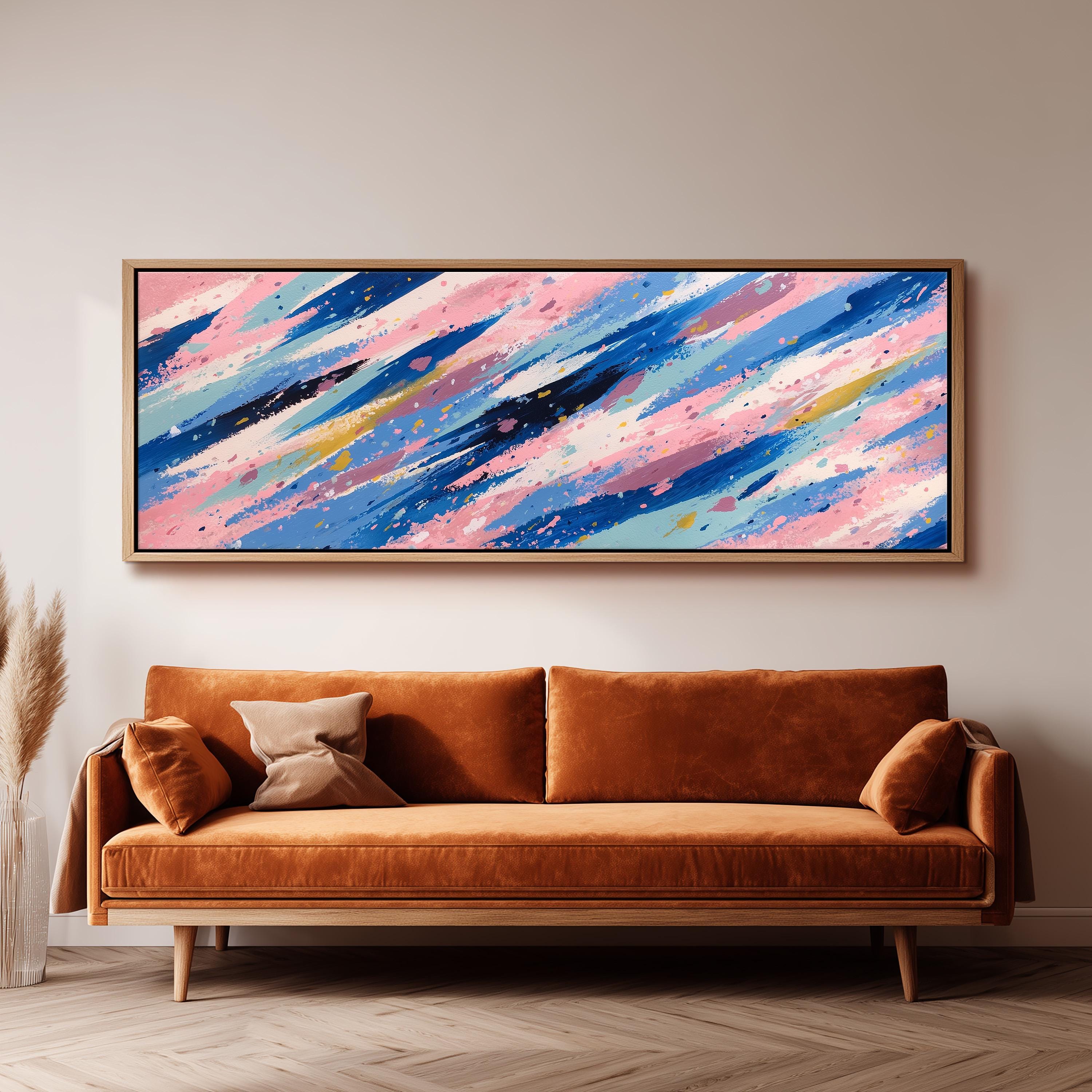 a large abstract painting hanging on a wall above a brown sofa with two pillows.
