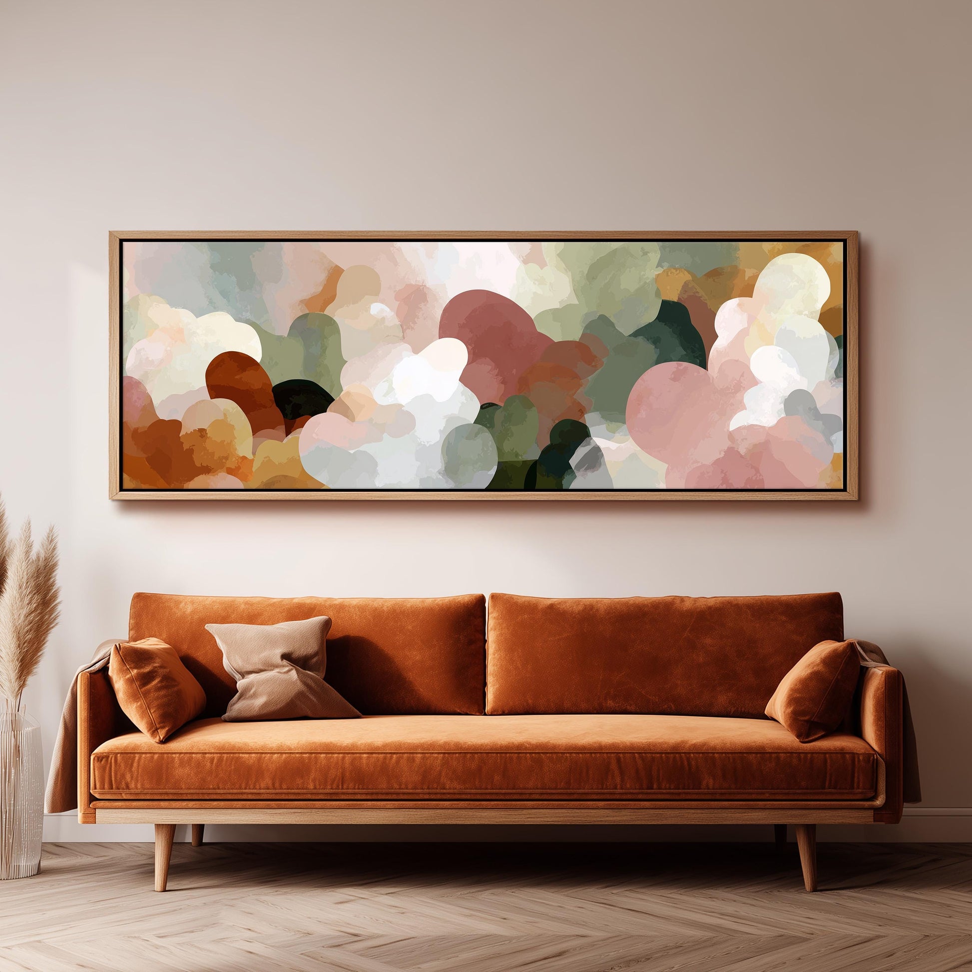 a large abstract painting hanging on a wall above a brown sofa with two pillows.