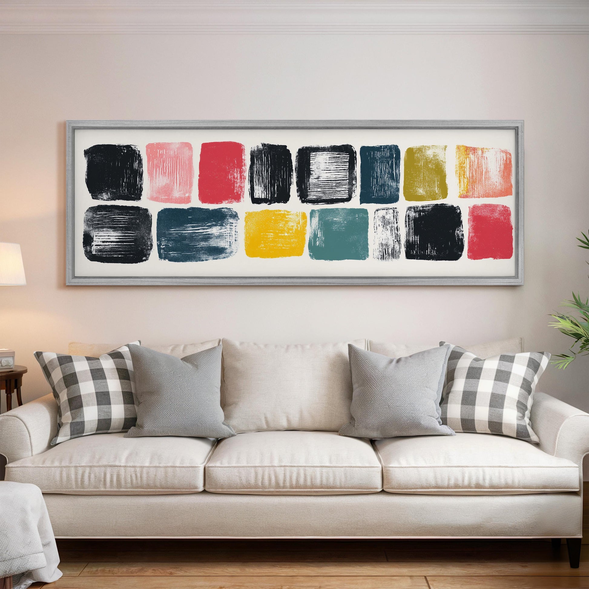a large, colorful abstract painting hanging on a wall above a white couch with gray and white plaid throw pillows.