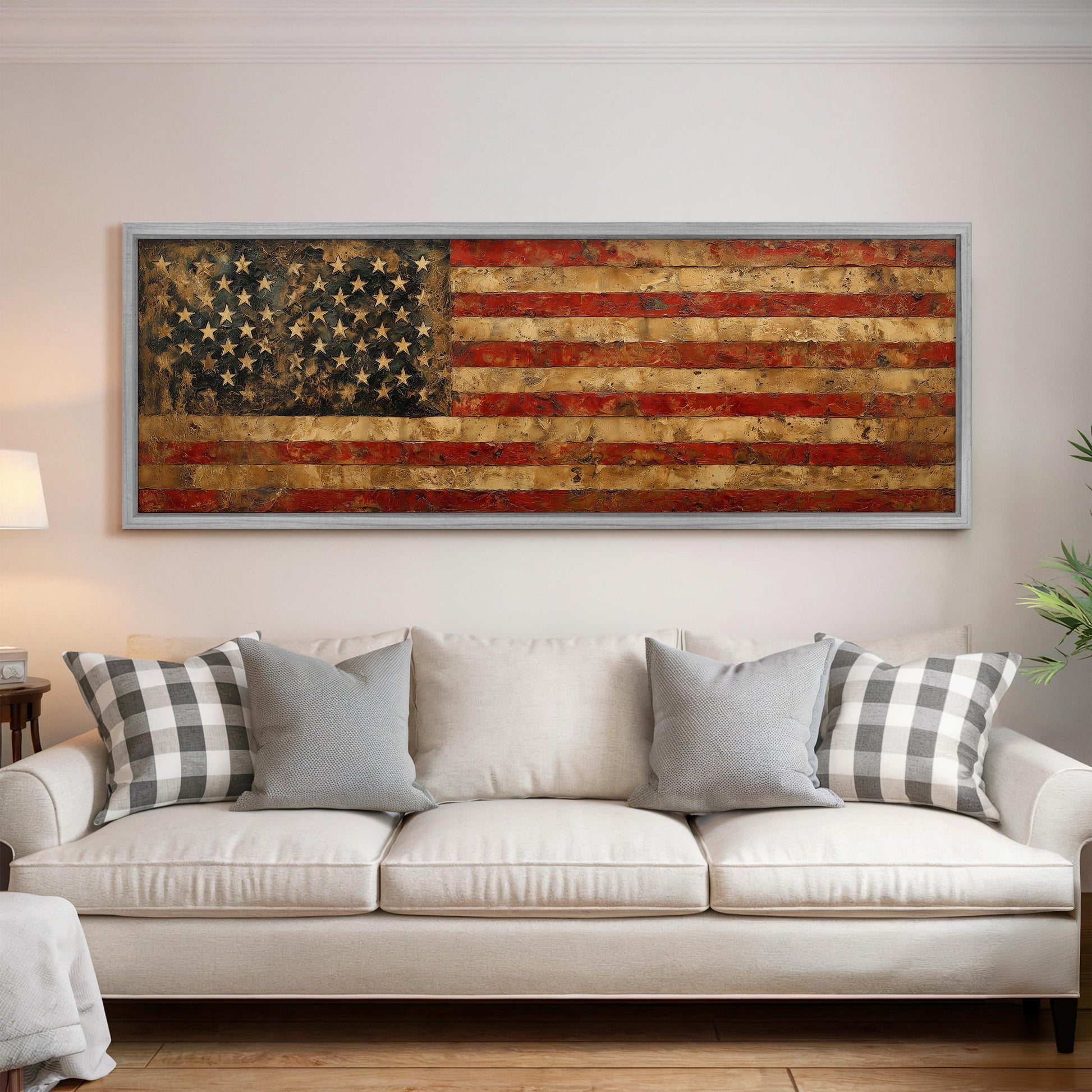 a large, framed American flag painting hanging on a wall above a white couch with gray and white plaid throw pillows.