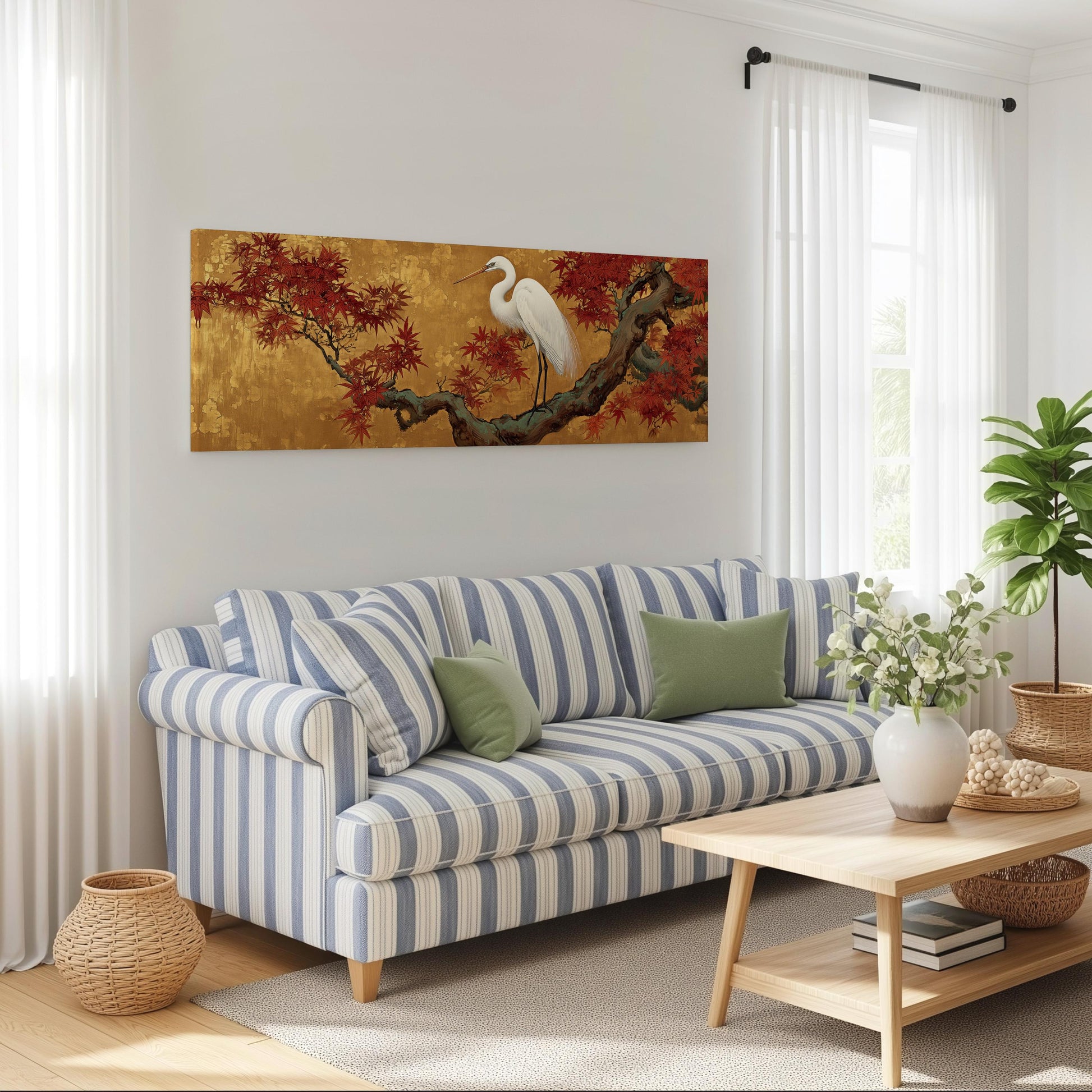 a cozy living room with a striped blue and white sofa, a wooden coffee table, and a large painting of a white heron perched on a branch with red leaves. The room is decorated with potted plants, a basket, and a vase with flowers, creating a warm and inviting atmosphere.