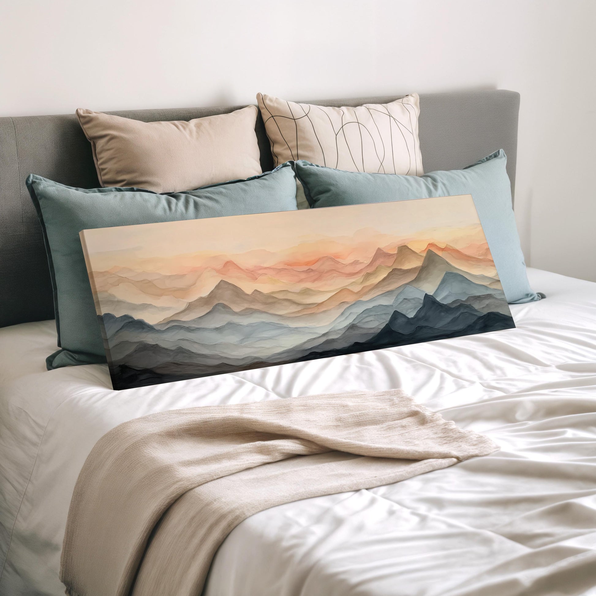 a bedroom with a bed covered in white sheets and a large painting of mountains on the bed. The painting features a landscape with mountains and a sunset sky.