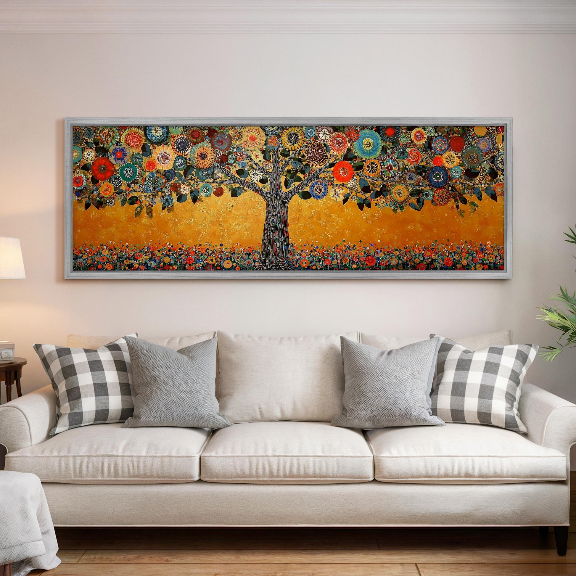 a large, colorful painting of a tree with flowers and leaves hanging on a wall above a white couch with gray and white pillows.