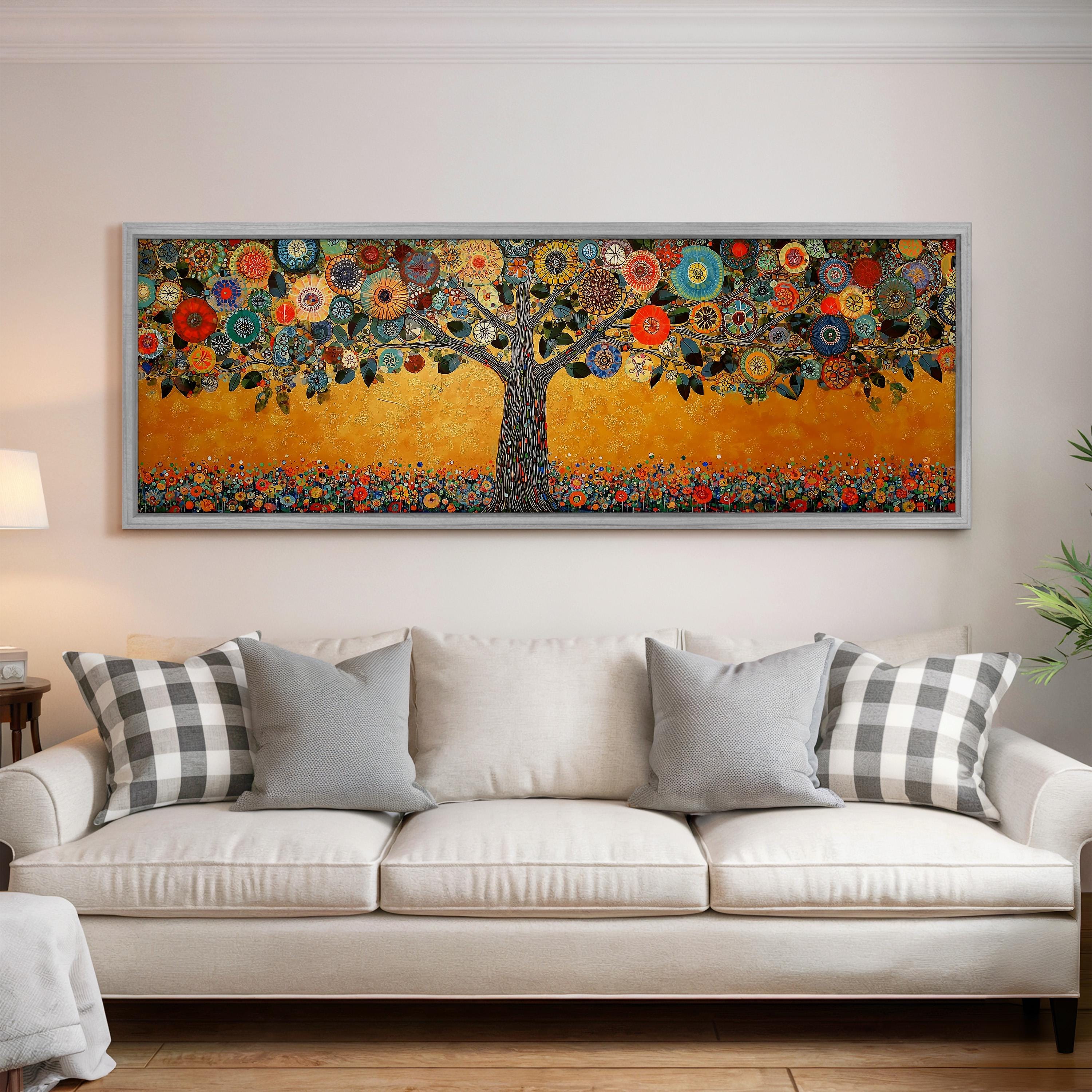 a large, colorful painting of a tree with flowers and leaves hanging on a wall above a white couch with gray and white pillows.