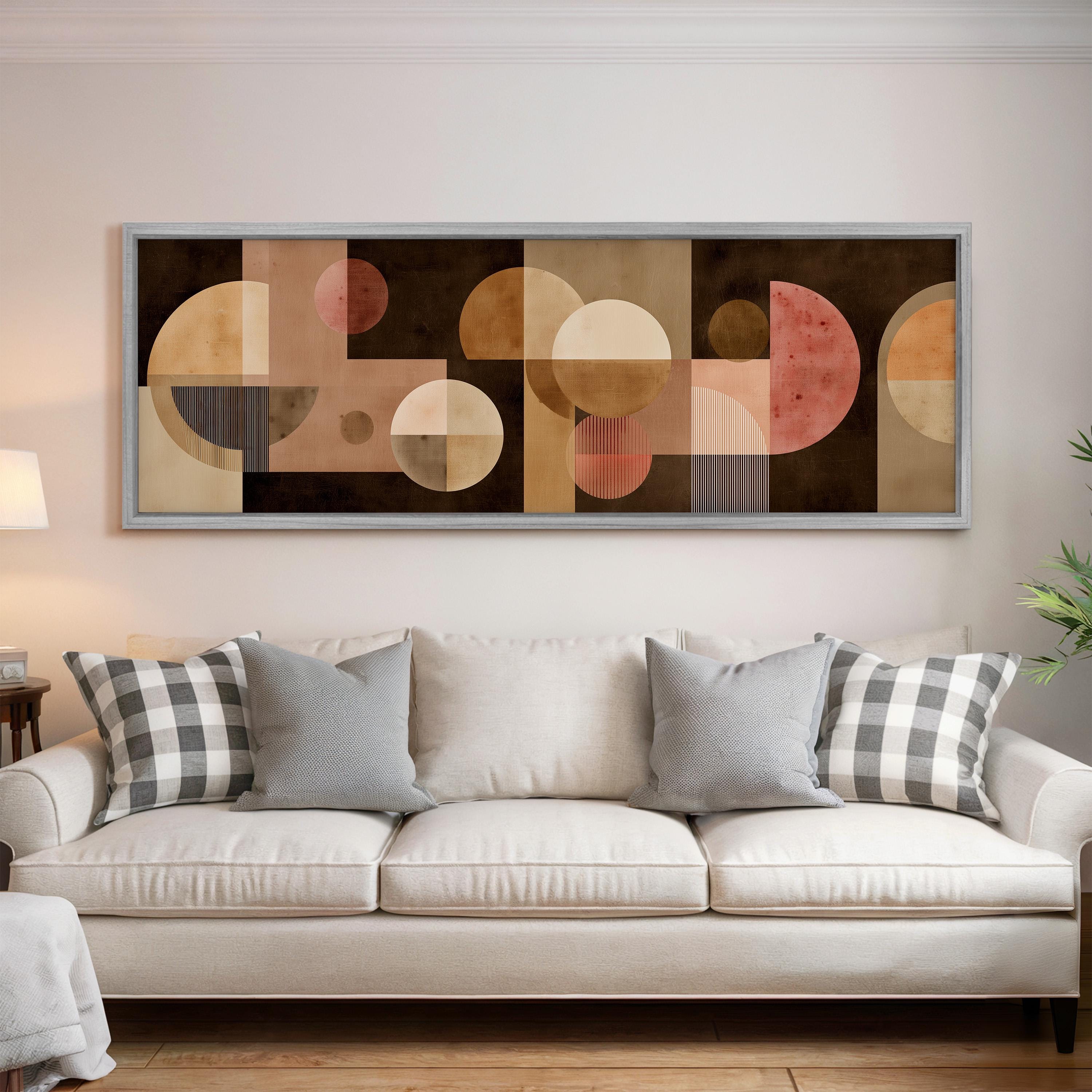 a large abstract painting hanging on a wall above a white couch with gray and white plaid throw pillows.