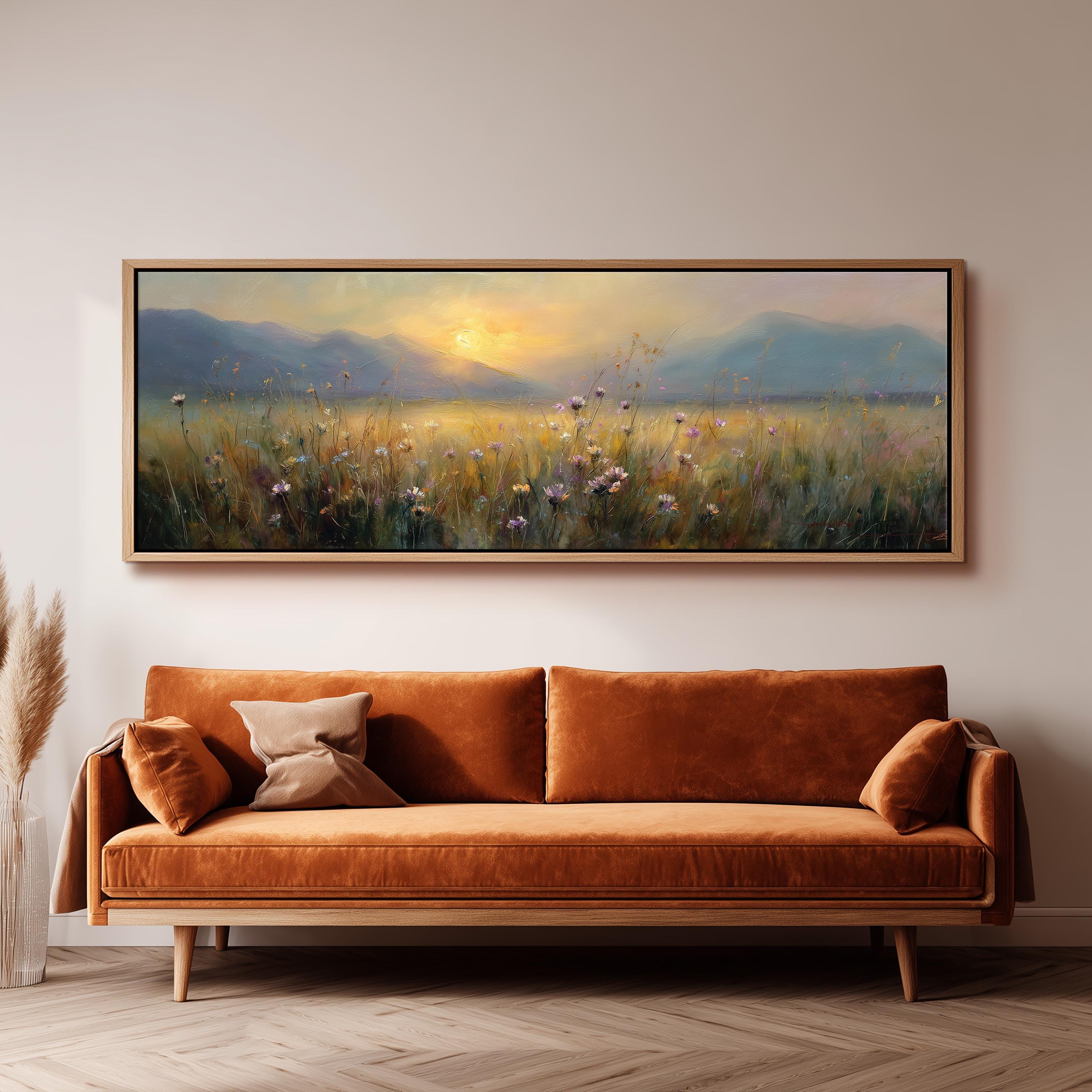 a large, rectangular painting hanging on a wall above a brown sofa with two pillows.