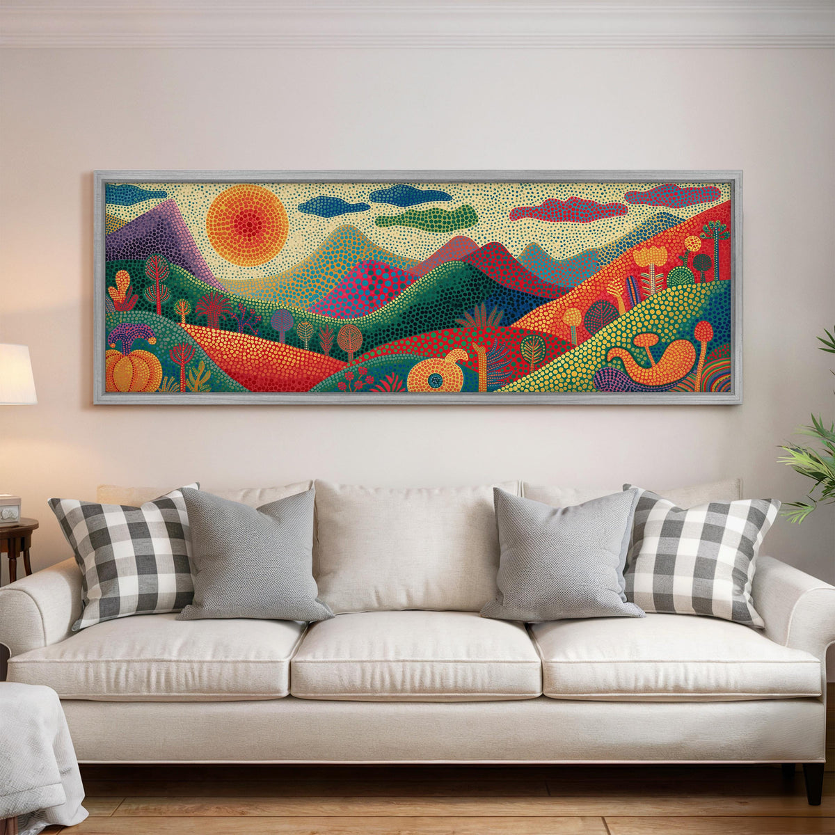 Dotted mountains under a sunburst panoramic canvas print above a white sofa in a bright living room