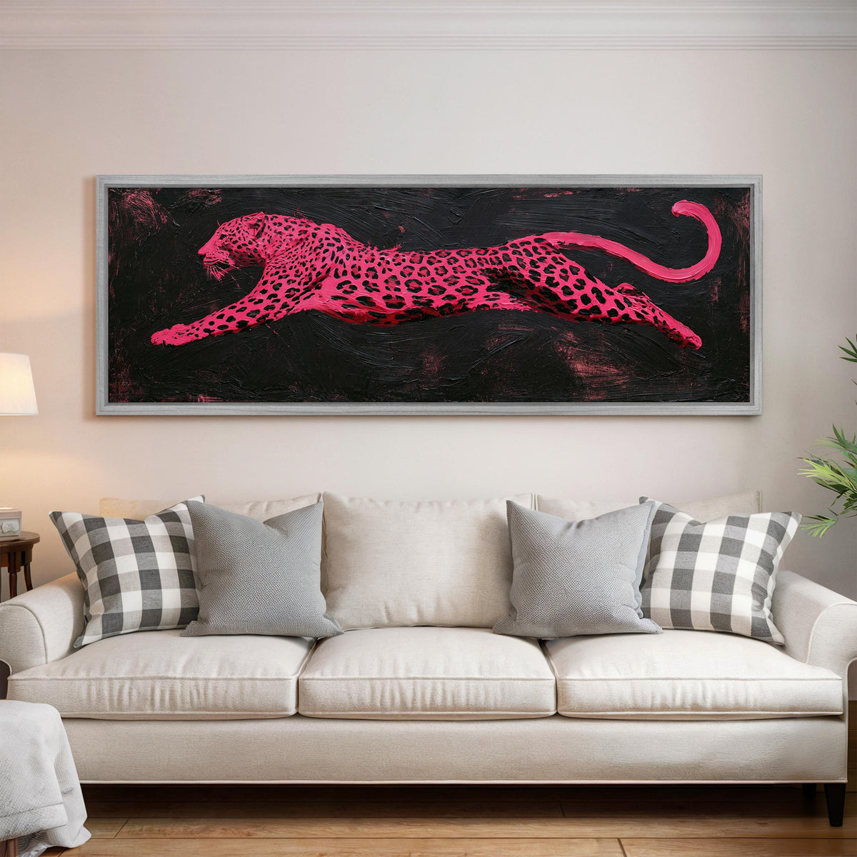Pink leaping leopard panoramic canvas print above a white sofa in a bright living room