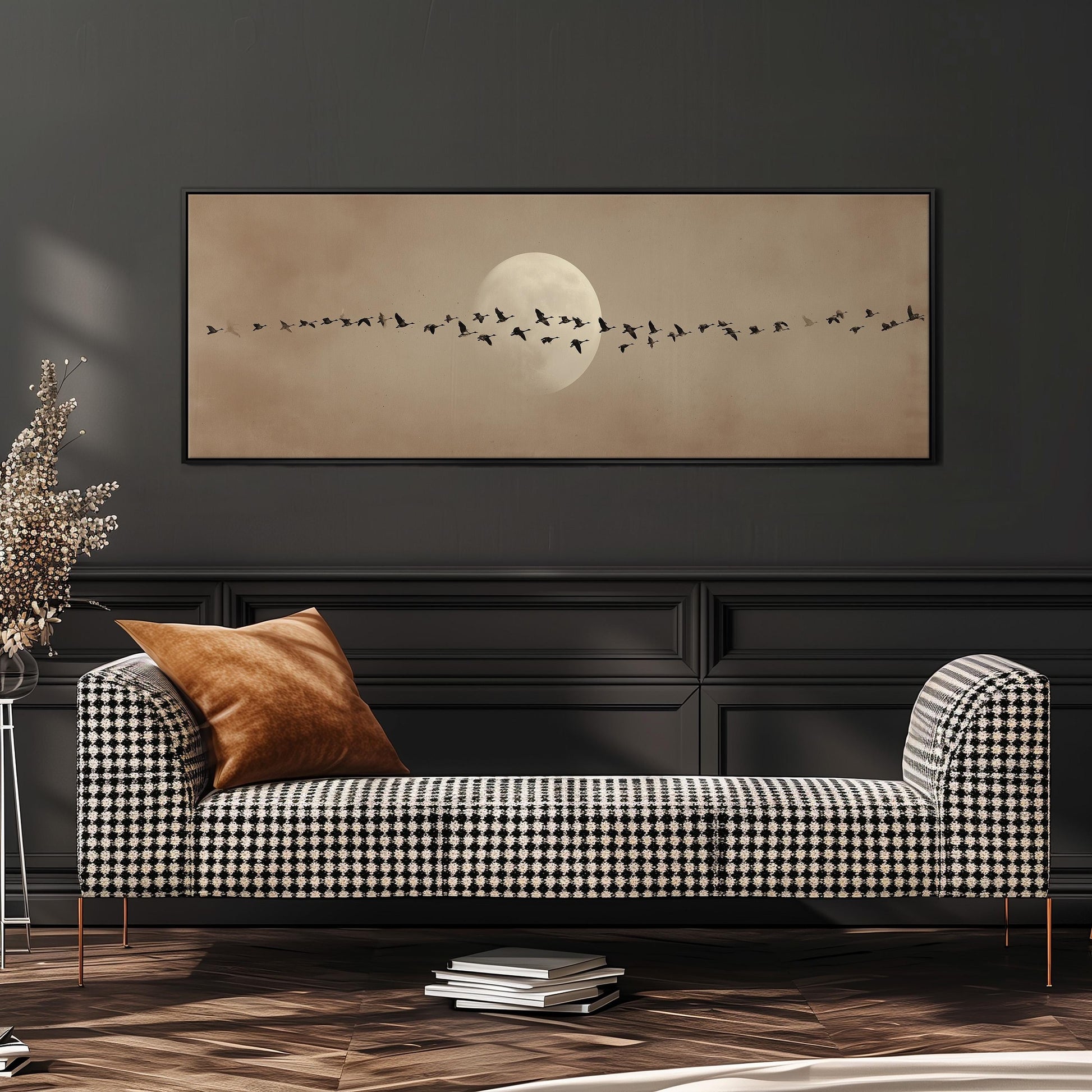 a checkered sofa with a brown throw pillow, set against a dark wall with a framed image of a flock of birds flying across the sky.