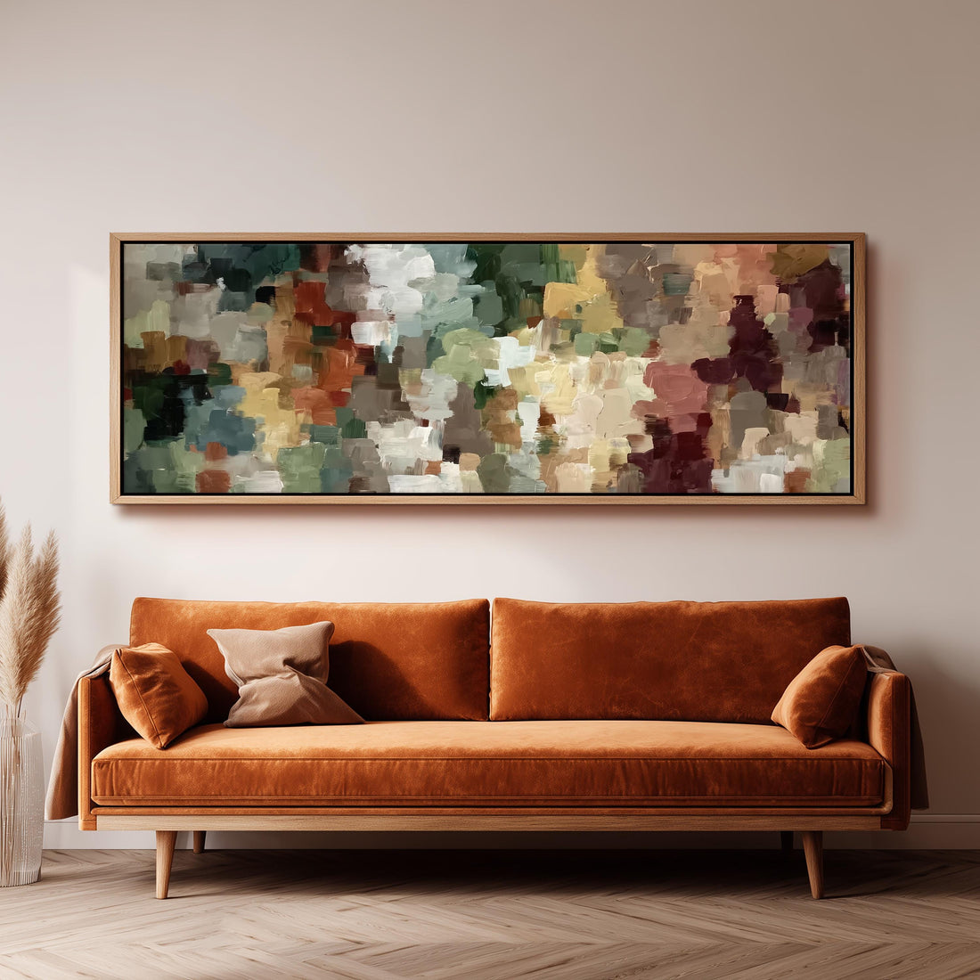 a large, abstract painting hanging on a wall above a brown sofa with orange cushions.