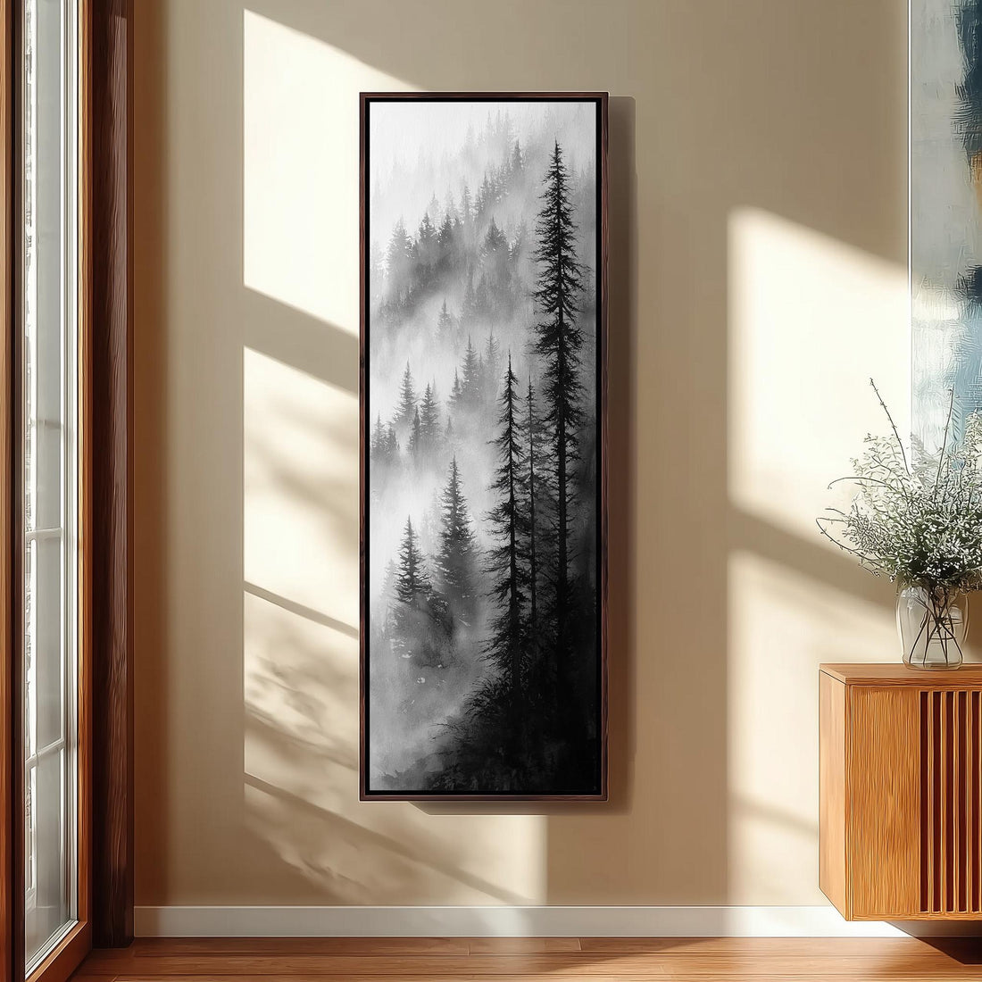 a large black and white painting of a forest scene hanging on a wall in a modern kitchen.