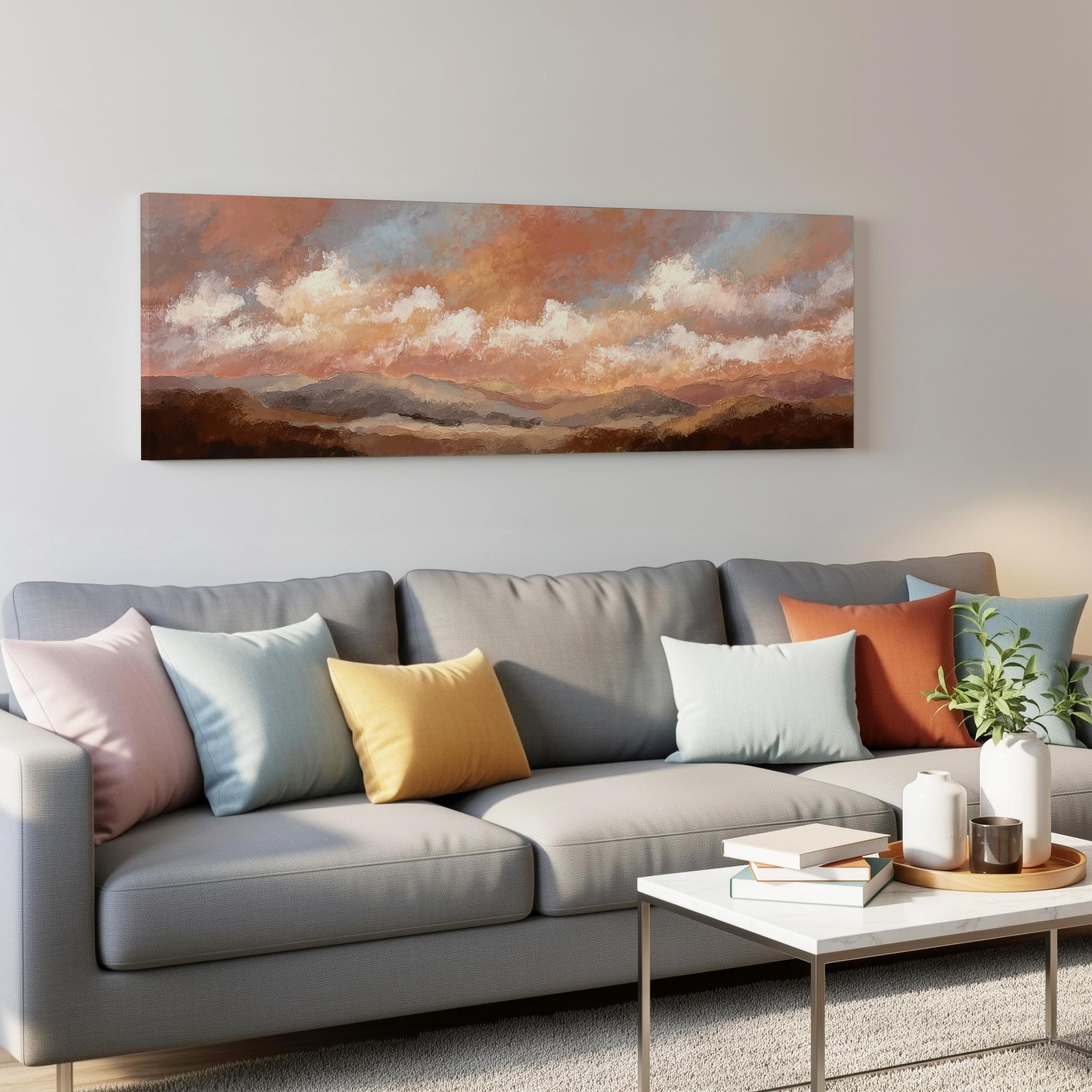 a gray couch with colorful throw pillows, a coffee table, and a painting of a landscape hanging on the wall above the couch.