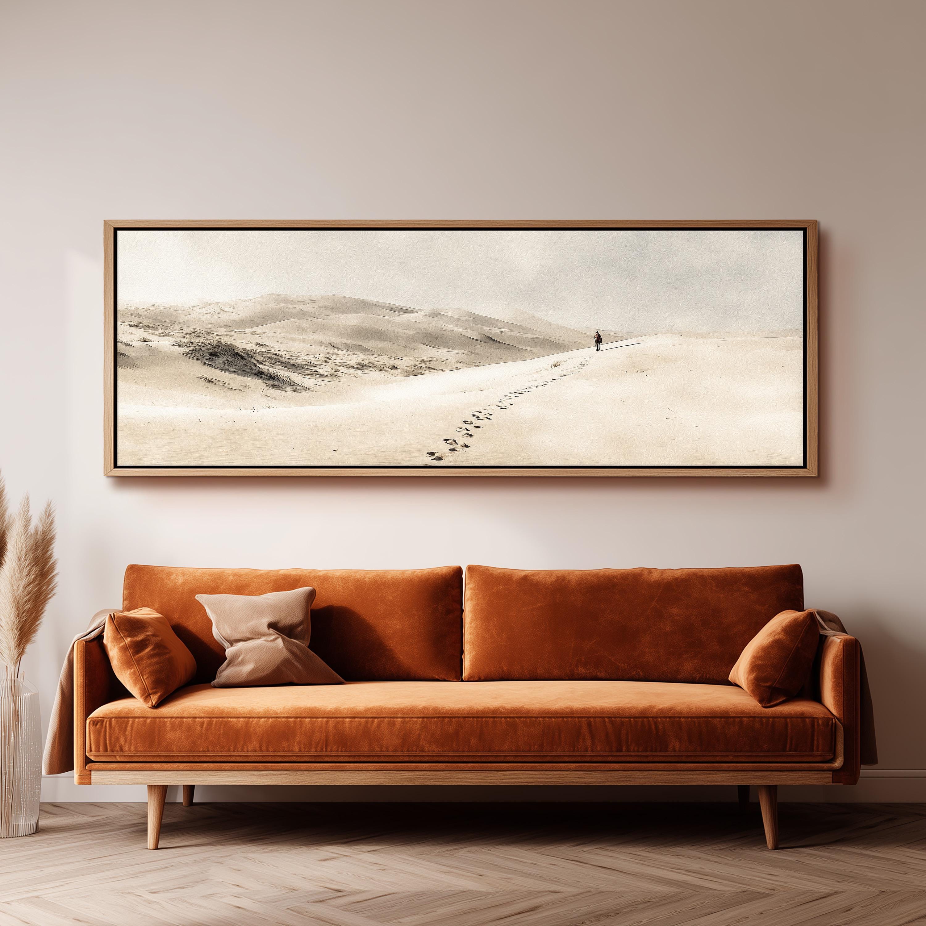 a large, framed painting of a snowy landscape hanging on a wall above a brown sofa.