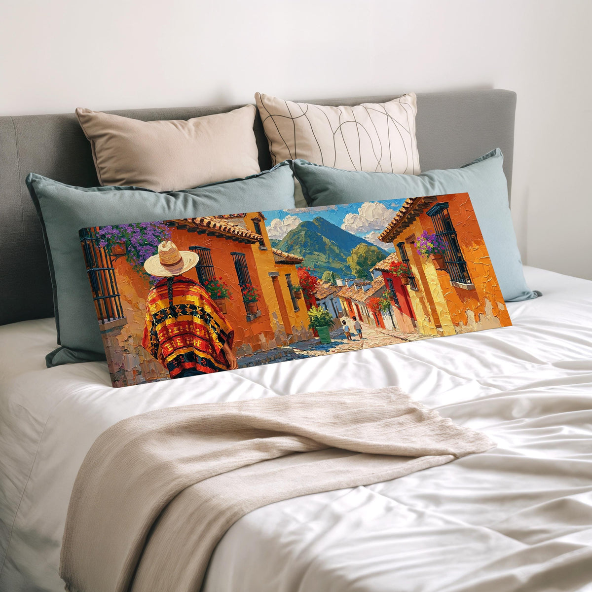 Colorful Guatemalan street with volcano view wide panoramic canvas print laid on a bed to show its size