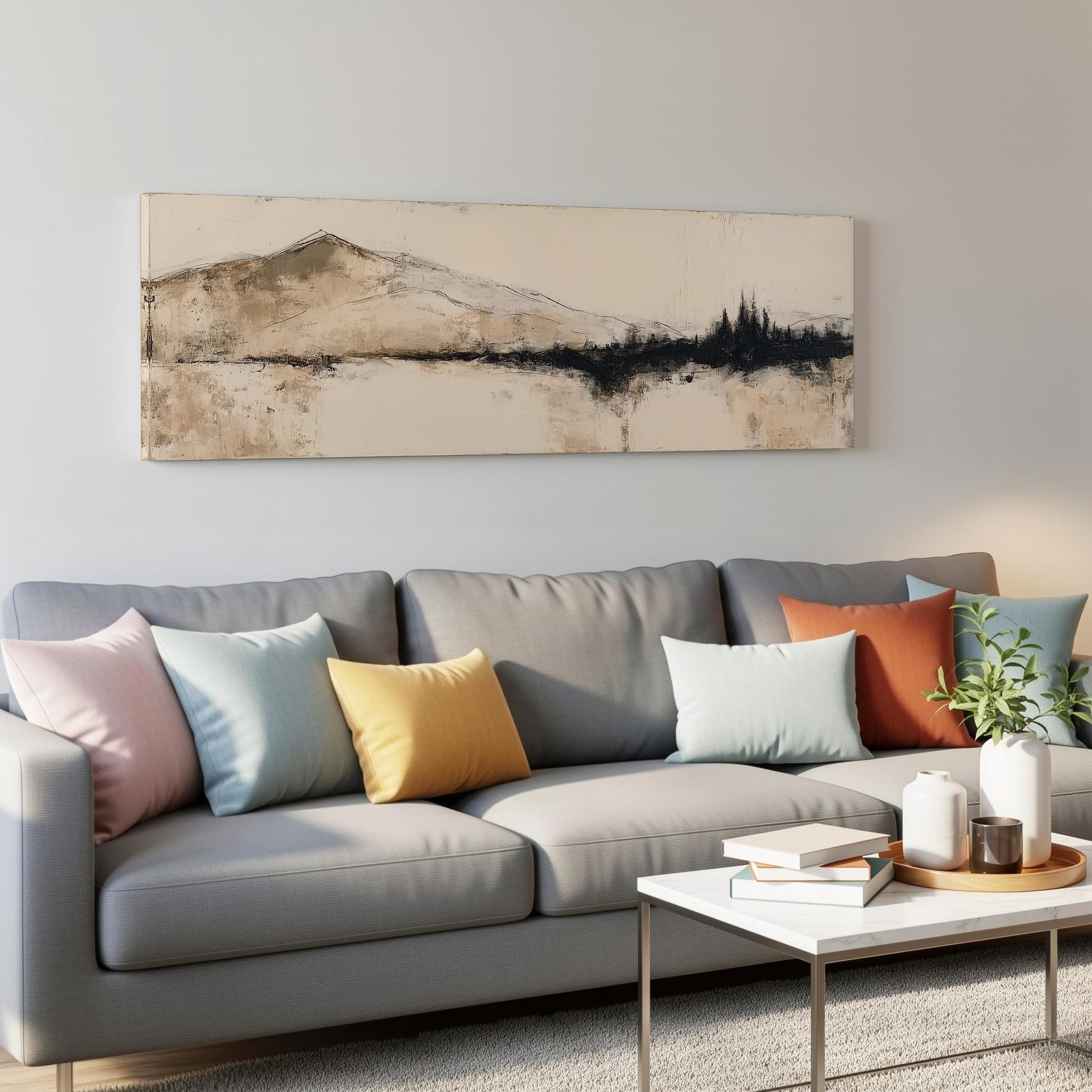 a modern living room with a gray sofa adorned with colorful throw pillows, a white coffee table, and a framed landscape painting hanging on the wall above the sofa.