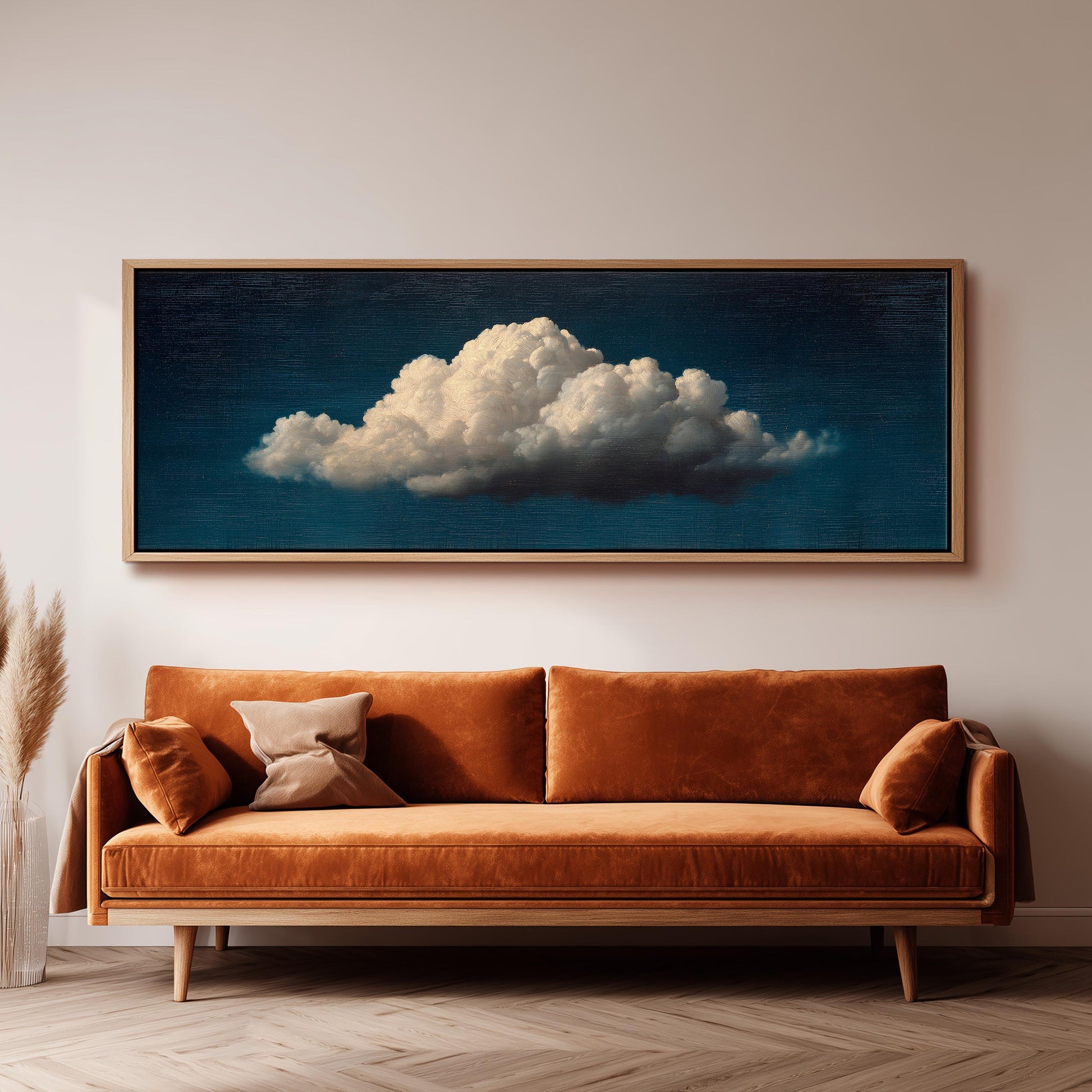 a large, framed painting of a cloud hanging on a wall above a brown sofa.