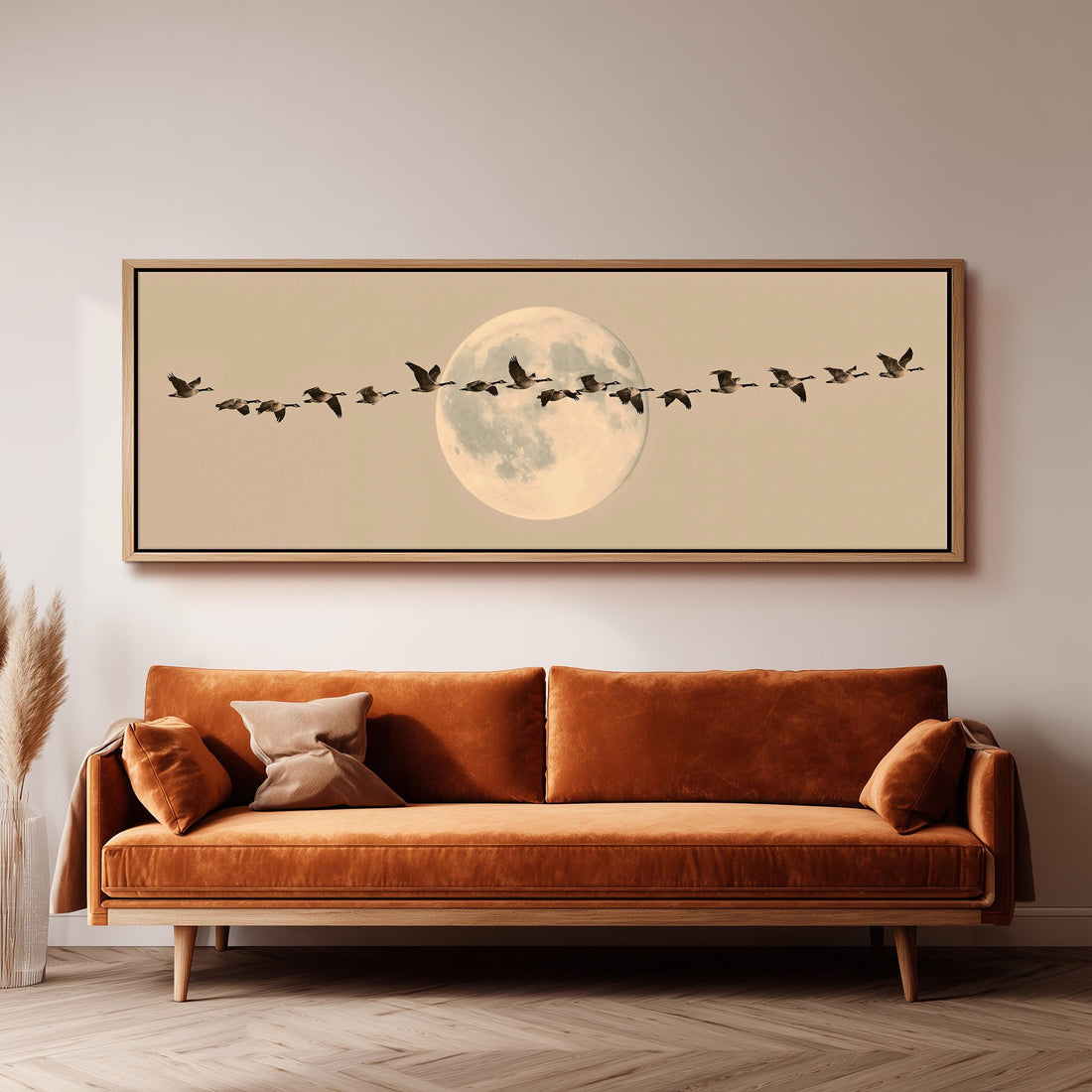 Geese flying across a pale moon on sand long horizontal canvas print above a sofa in a living room