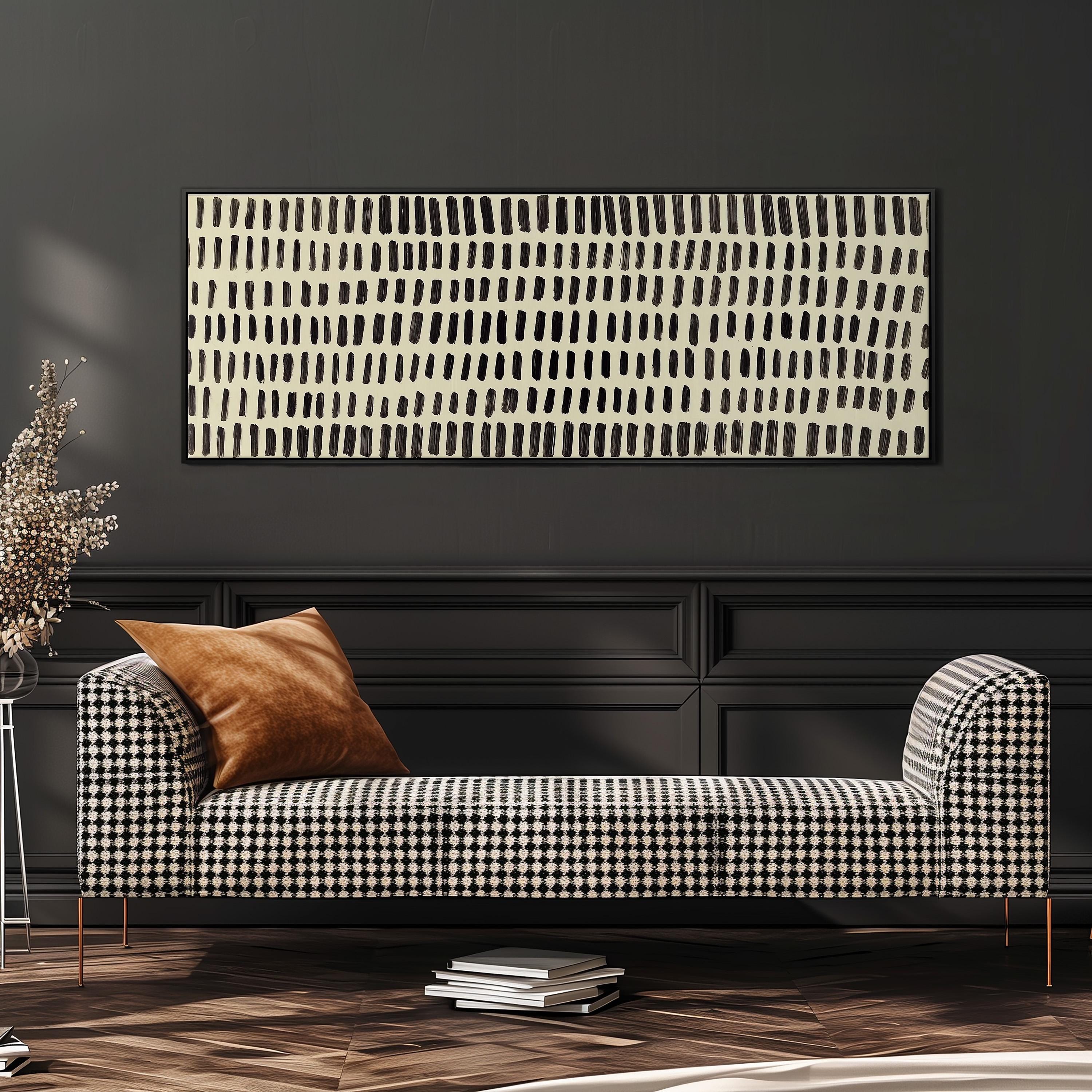 a modern living room with a black and white checkered sofa, a stack of books, and a large abstract painting on the wall.