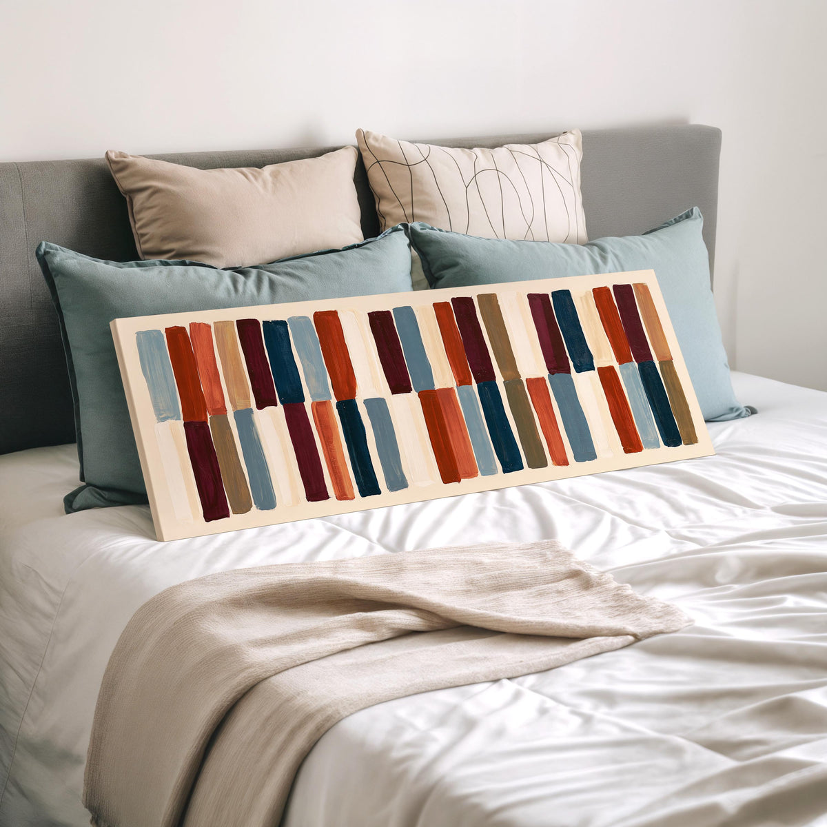 Two tiers of staggered stripe blocks wide panoramic canvas print laid on a bed to show its size