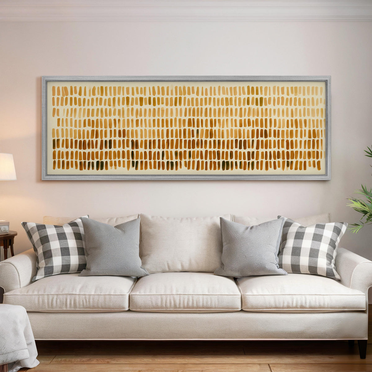 Brushmarks fading from cream to amber panoramic canvas print above a white sofa in a bright living room