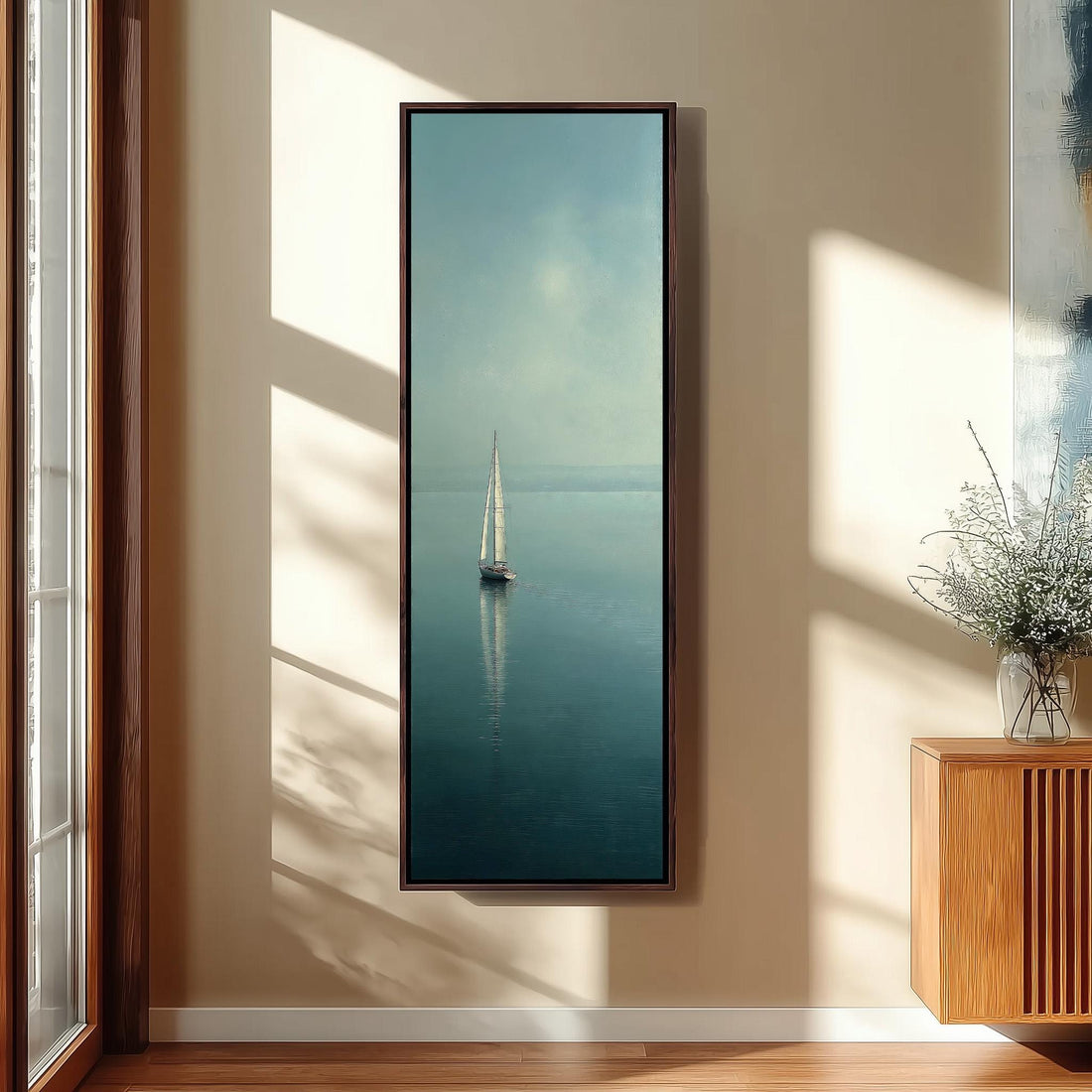 a large framed picture of a sailboat on the water, hanging on a wall in a modern kitchen.