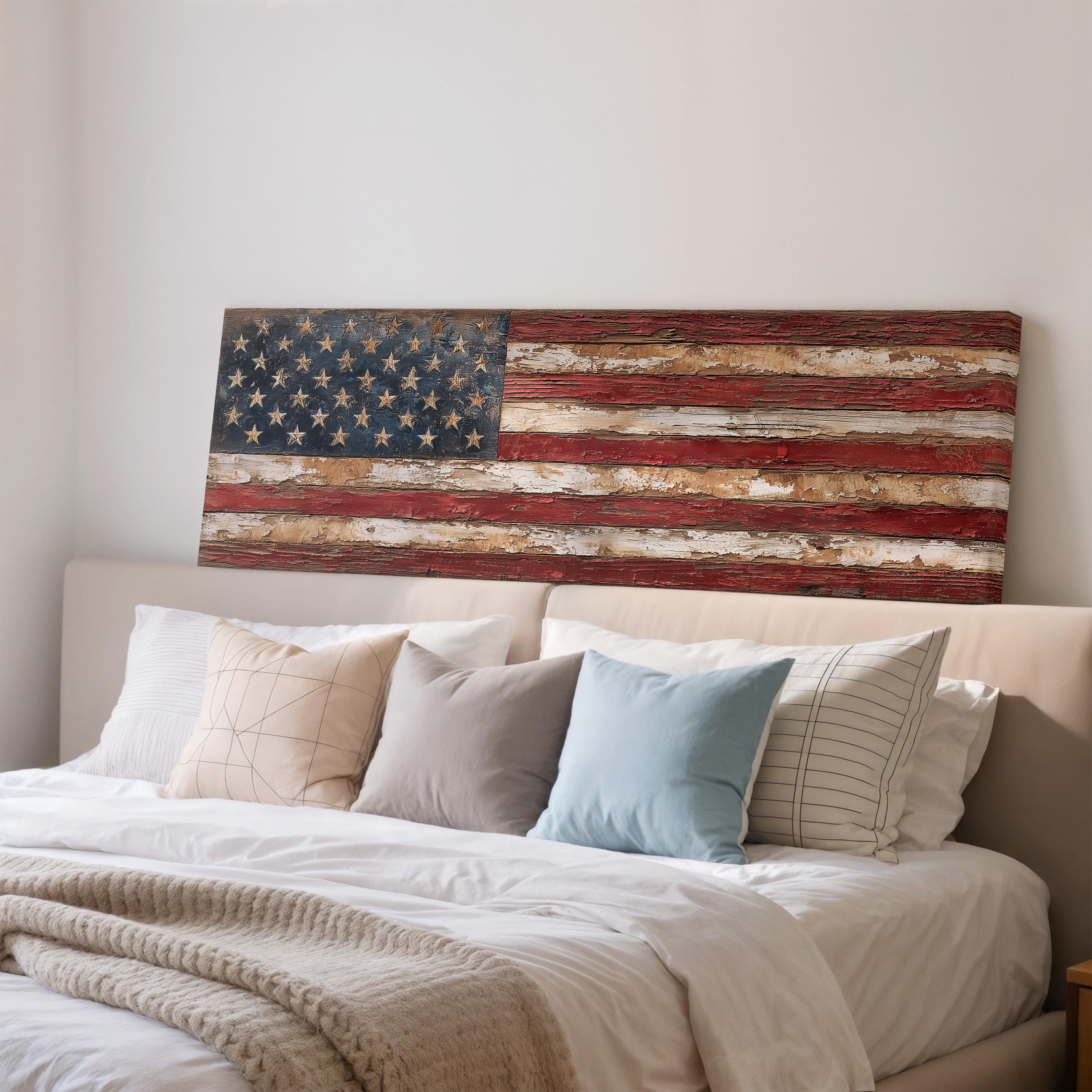 a bedroom with a bed and a large American flag displayed on the wall above it.