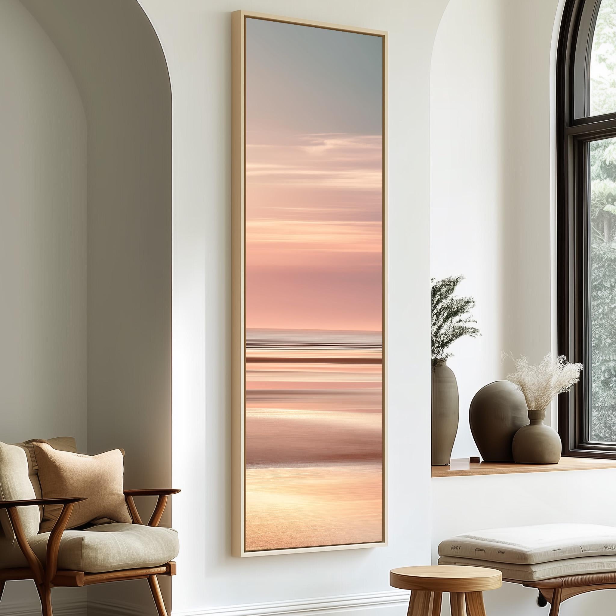 a large, framed painting of a sunset over a beach, hanging on a wall in a modern living room setting.