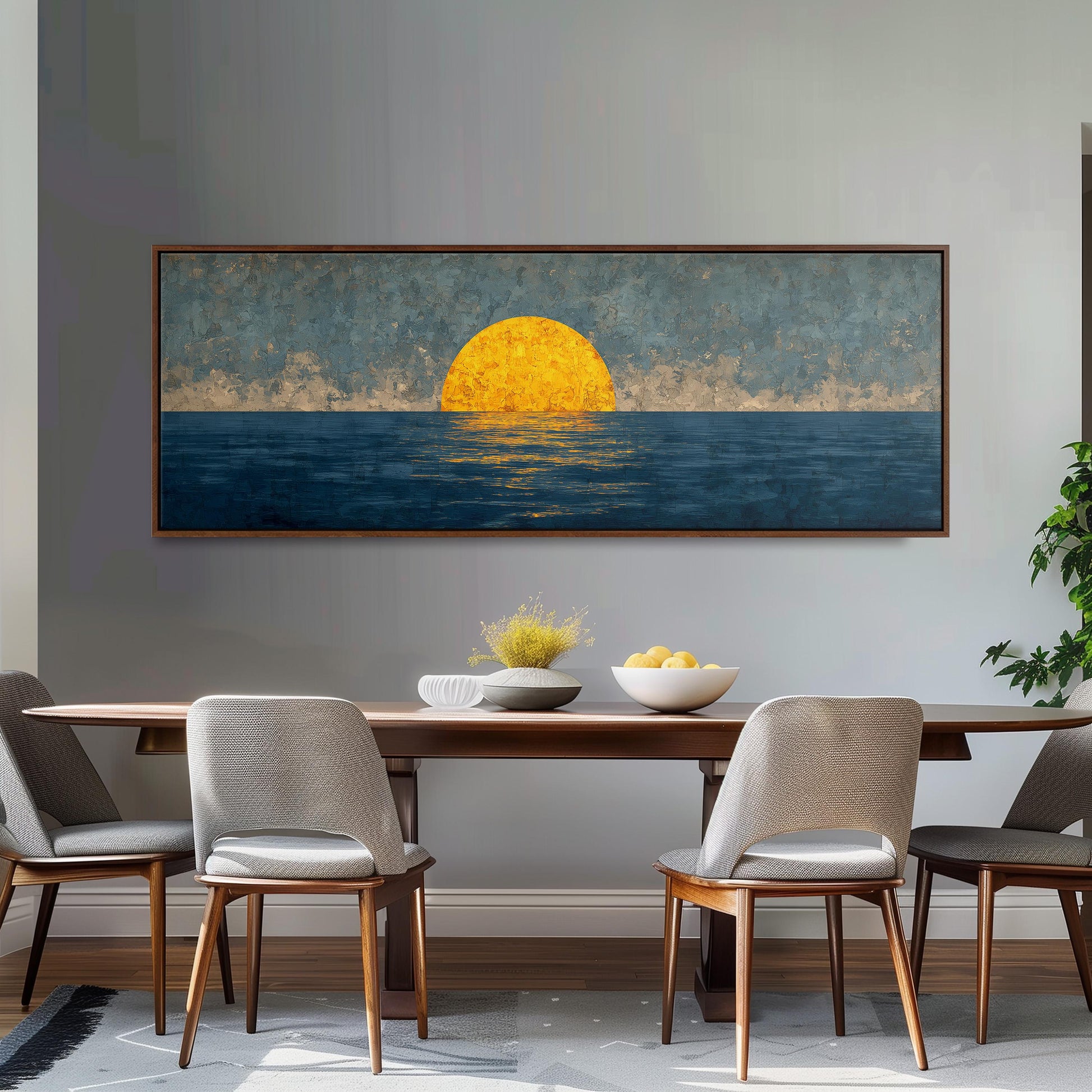 a large painting of a sunset over the ocean, hanging on a wall above a wooden dining table with four chairs.