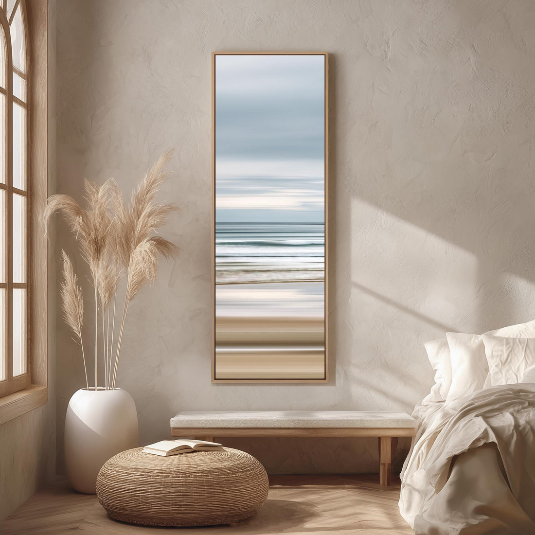 a serene bedroom scene with a large window, a painting of a beach, a white bench, a woven ottoman, and a potted plant.