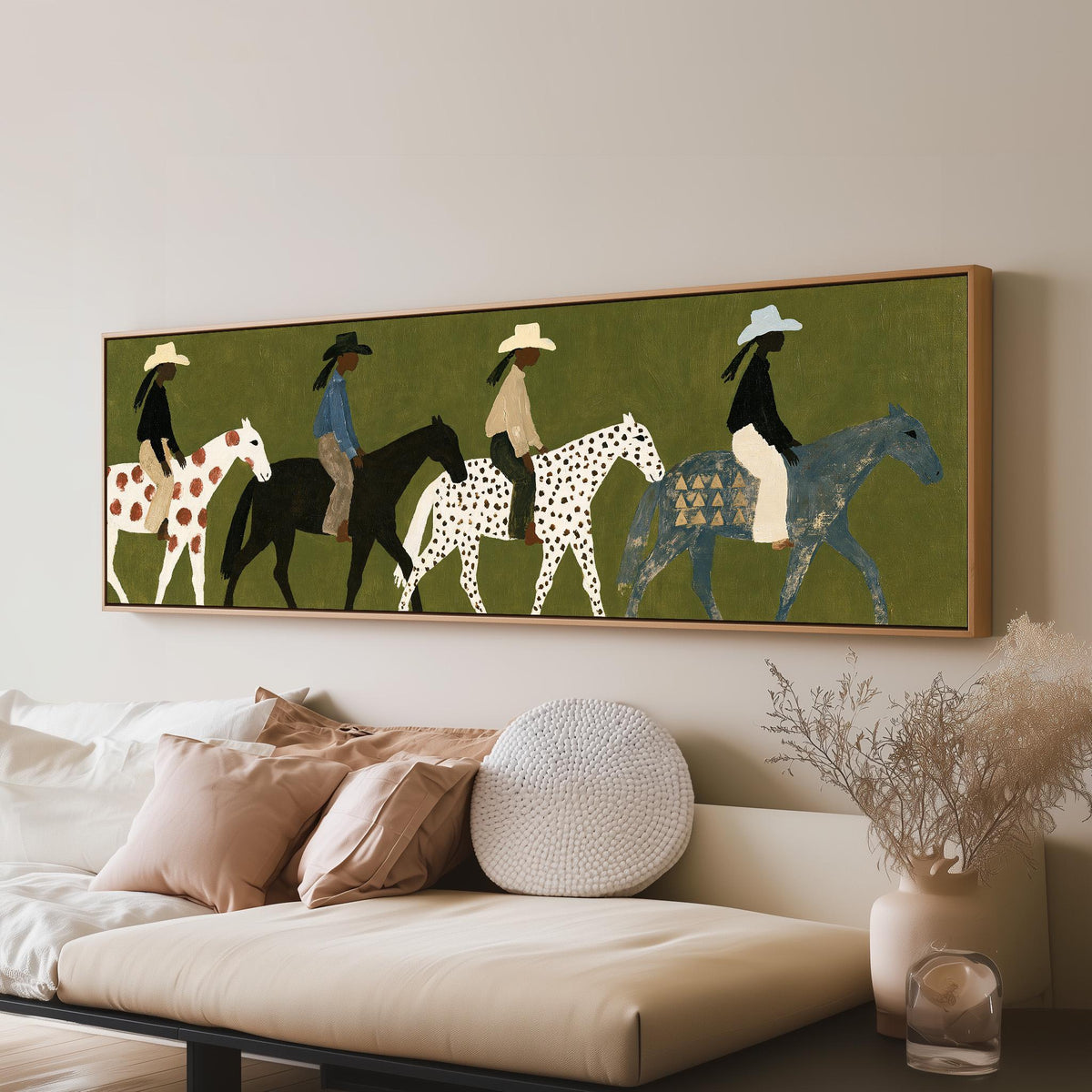 Riders on spotted ponies on olive green panoramic canvas print above a sofa in a living room