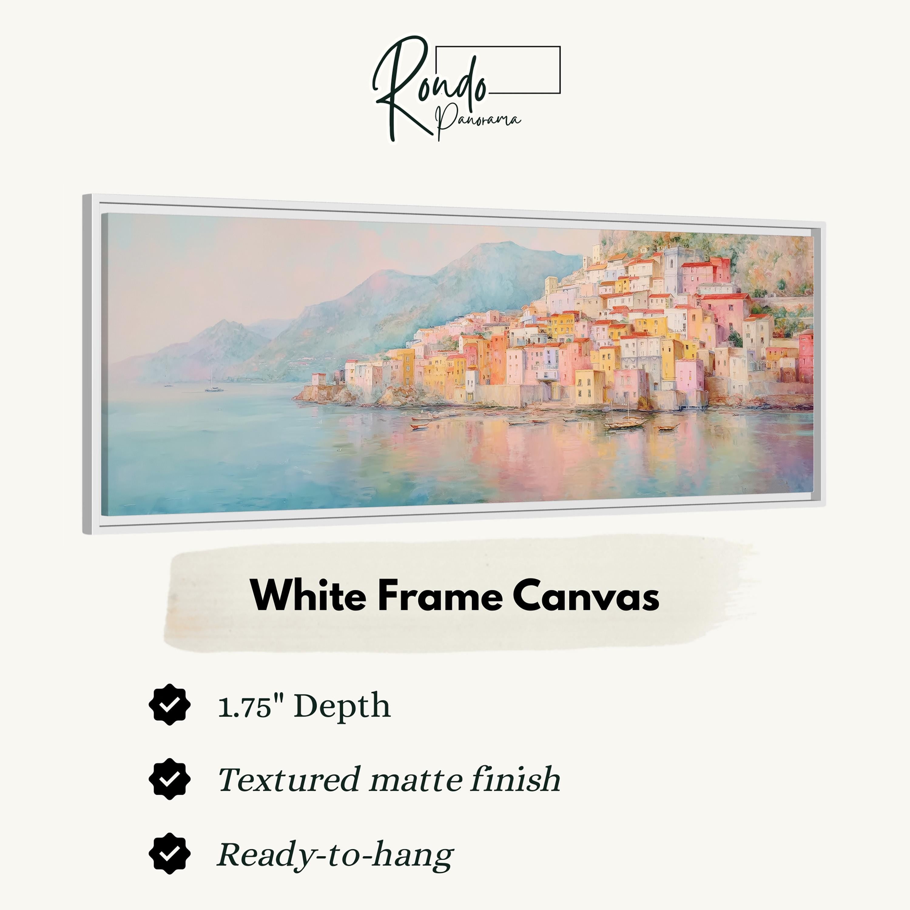 The image is a white frame canvas depicting a coastal town with colorful buildings and a body of water in the background.