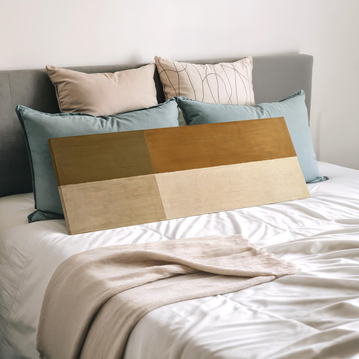 Olive and cream quadrants wide panoramic canvas print laid on a bed to show its size