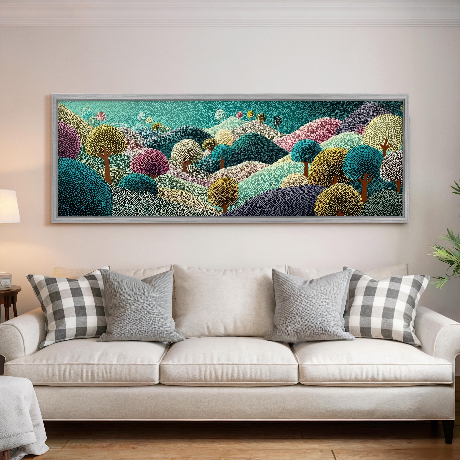a large, colorful painting of a landscape hanging on a wall above a white couch with patterned throw pillows.