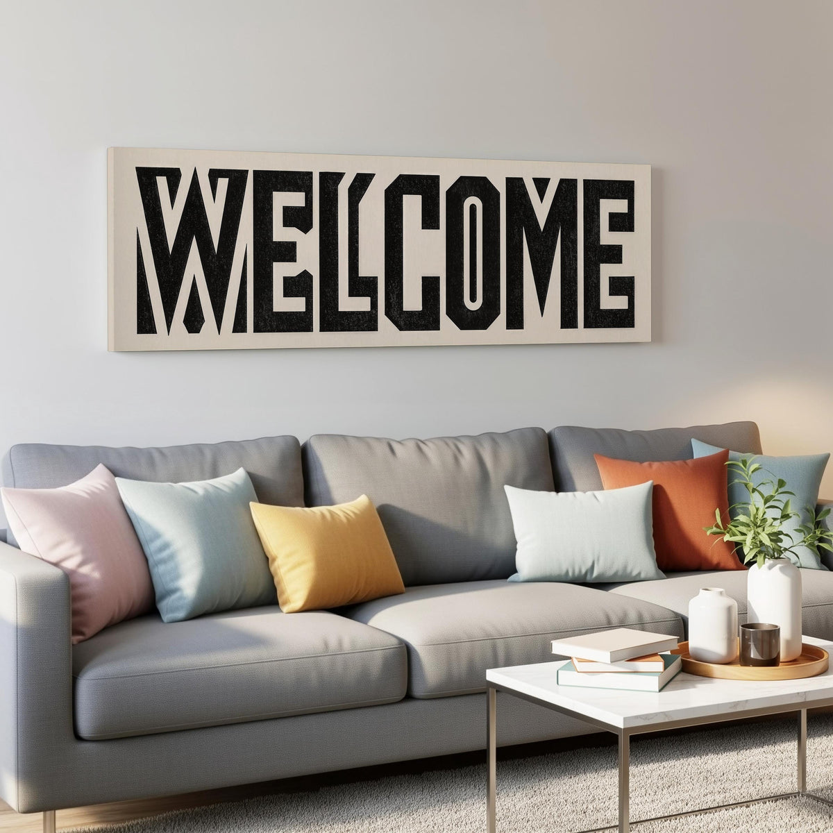 Bold welcome block letters panoramic canvas print above a grey sofa in a living room