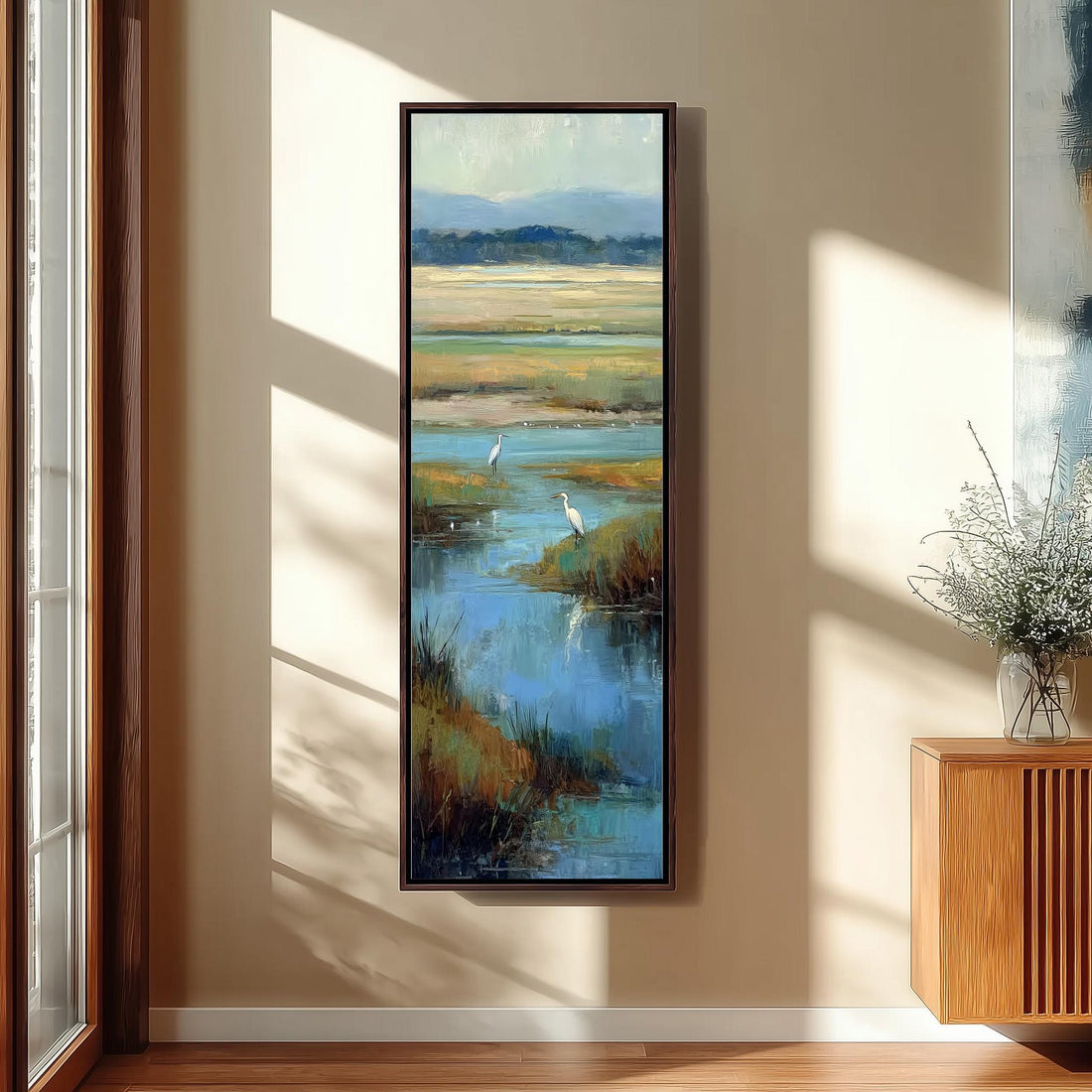 a large framed painting hanging on a wall, depicting a serene landscape with a body of water and two white birds.