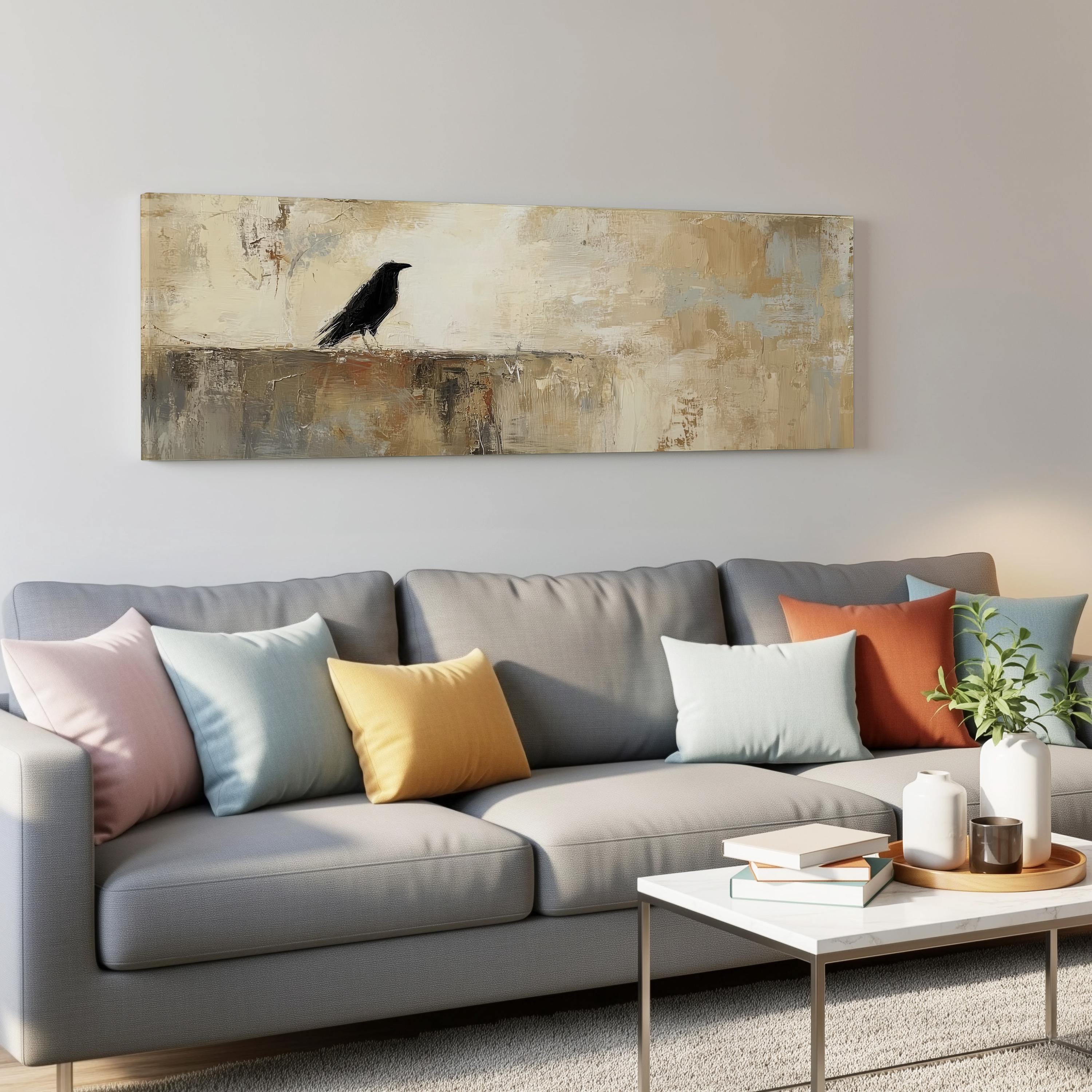 a gray couch with colorful throw pillows, a coffee table, and a painting of a black bird on the wall above the couch.