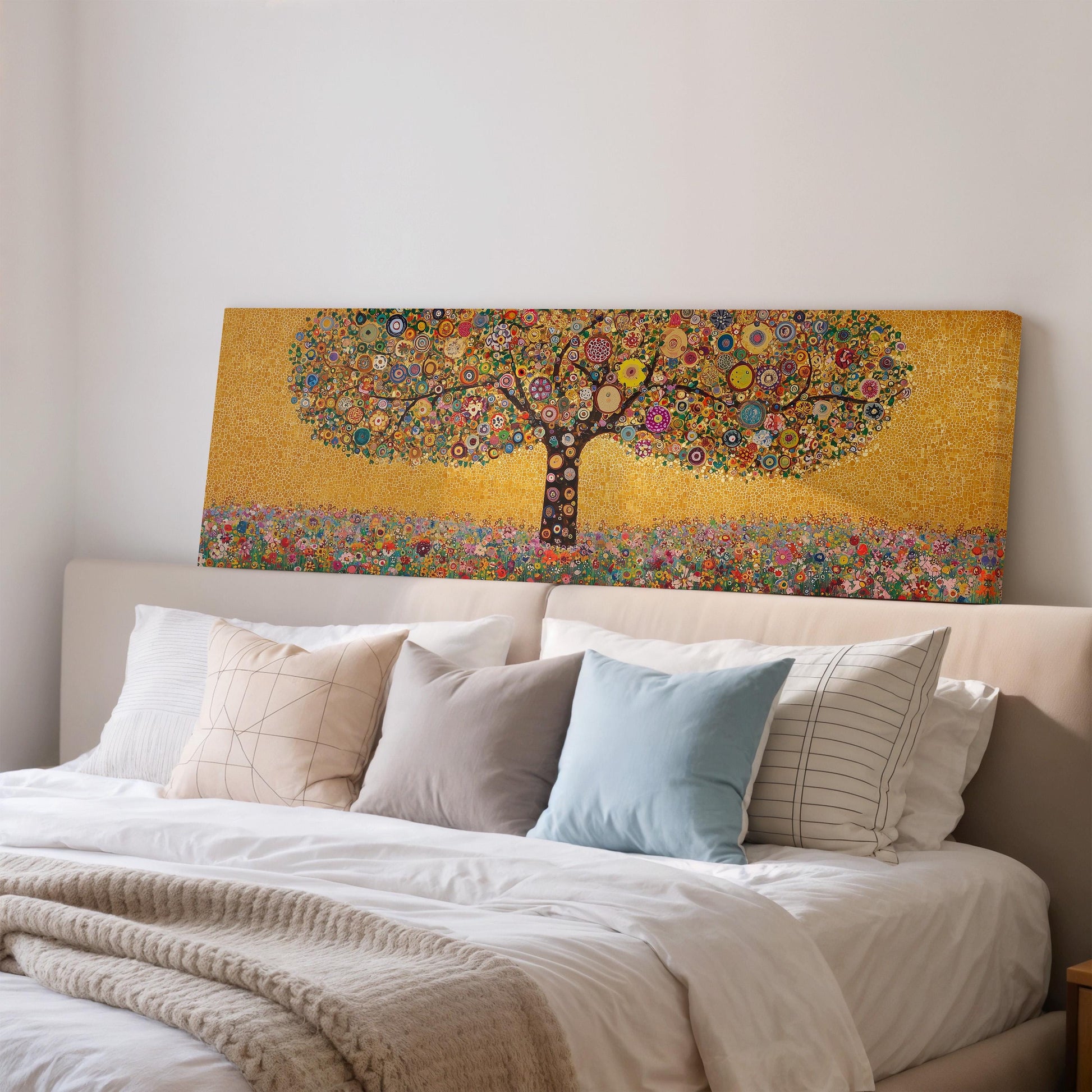 a large, colorful painting of a tree with a golden background, hanging above a bed with white pillows and a gray blanket.