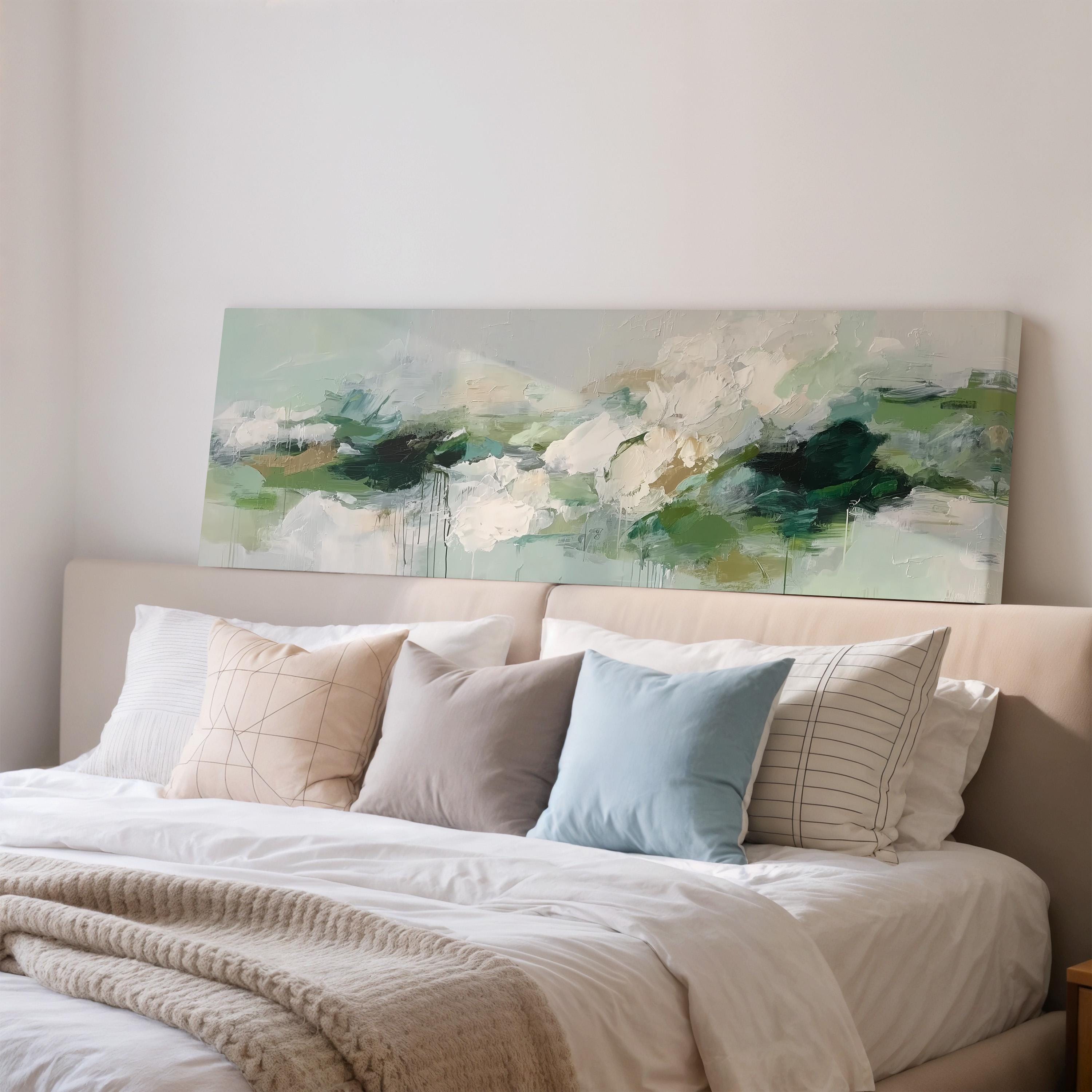 a cozy bedroom with a large bed adorned with white sheets and a blue pillow. Above the bed, there is a large abstract painting featuring a landscape with green and white colors.