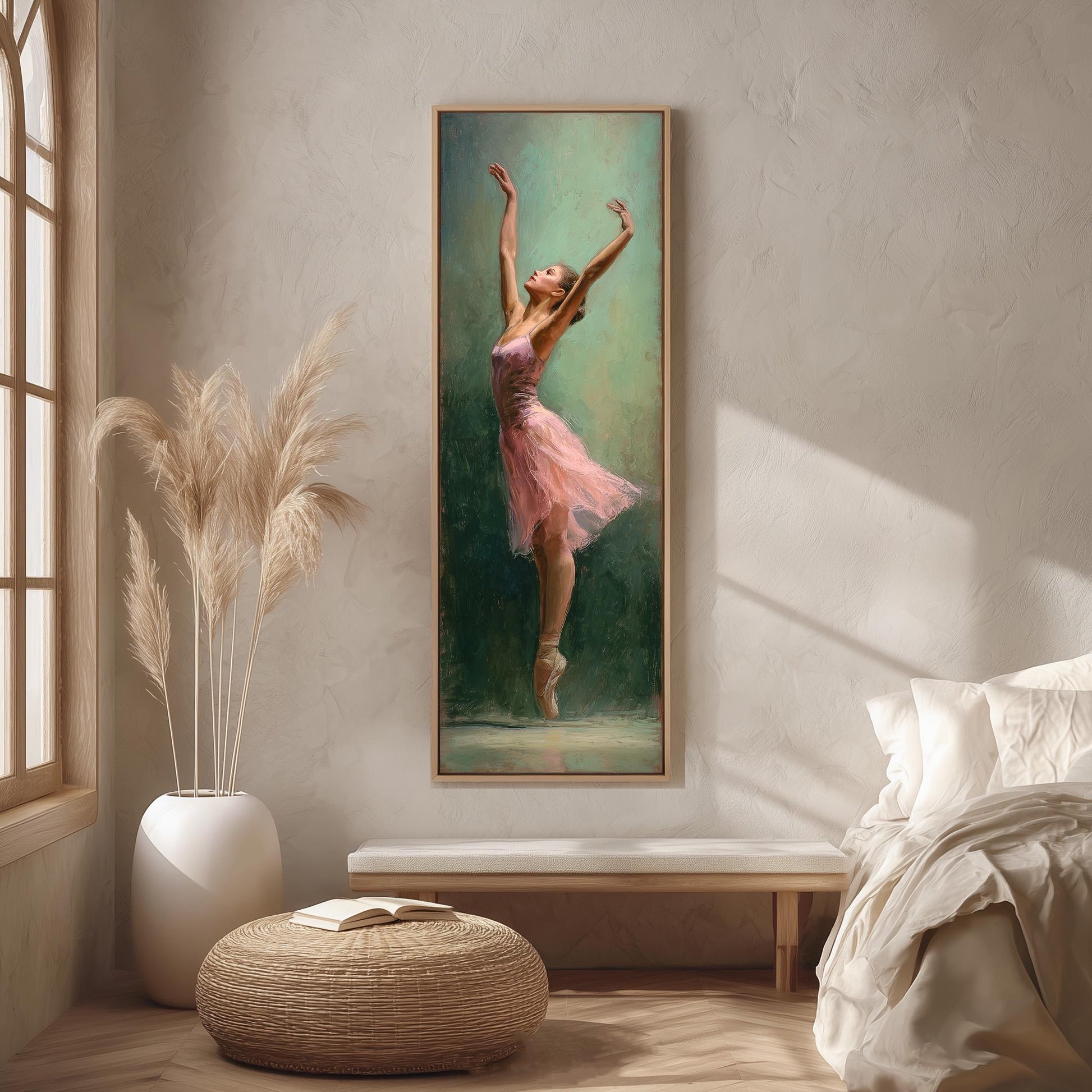 a painting of a woman in a pink tutu, with her arms raised, hanging on a wall in a room with a window, a white vase, and a woven ottoman.