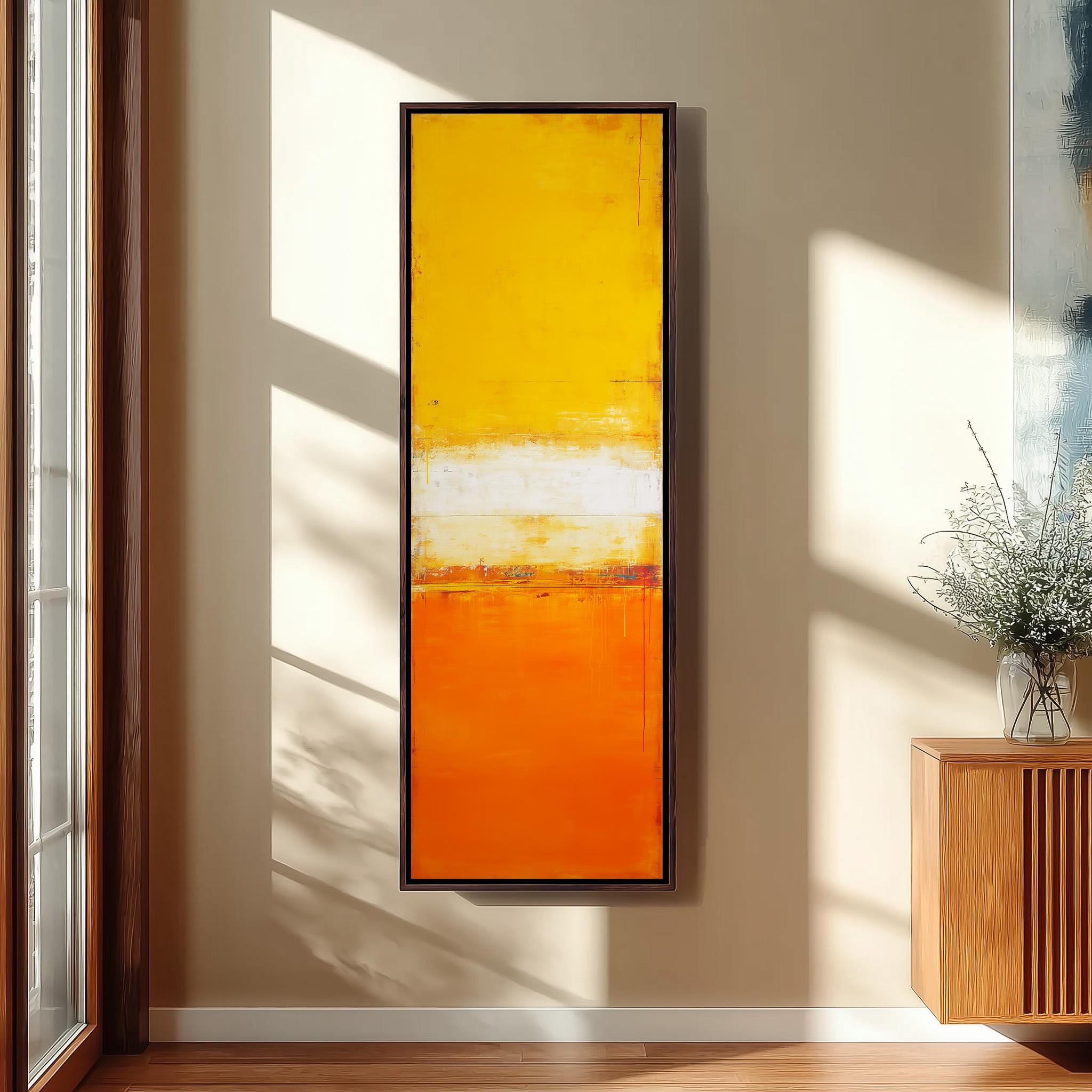 a large, vibrant abstract painting hanging on a wall, with a wooden cabinet and a vase of flowers to the right of the painting.