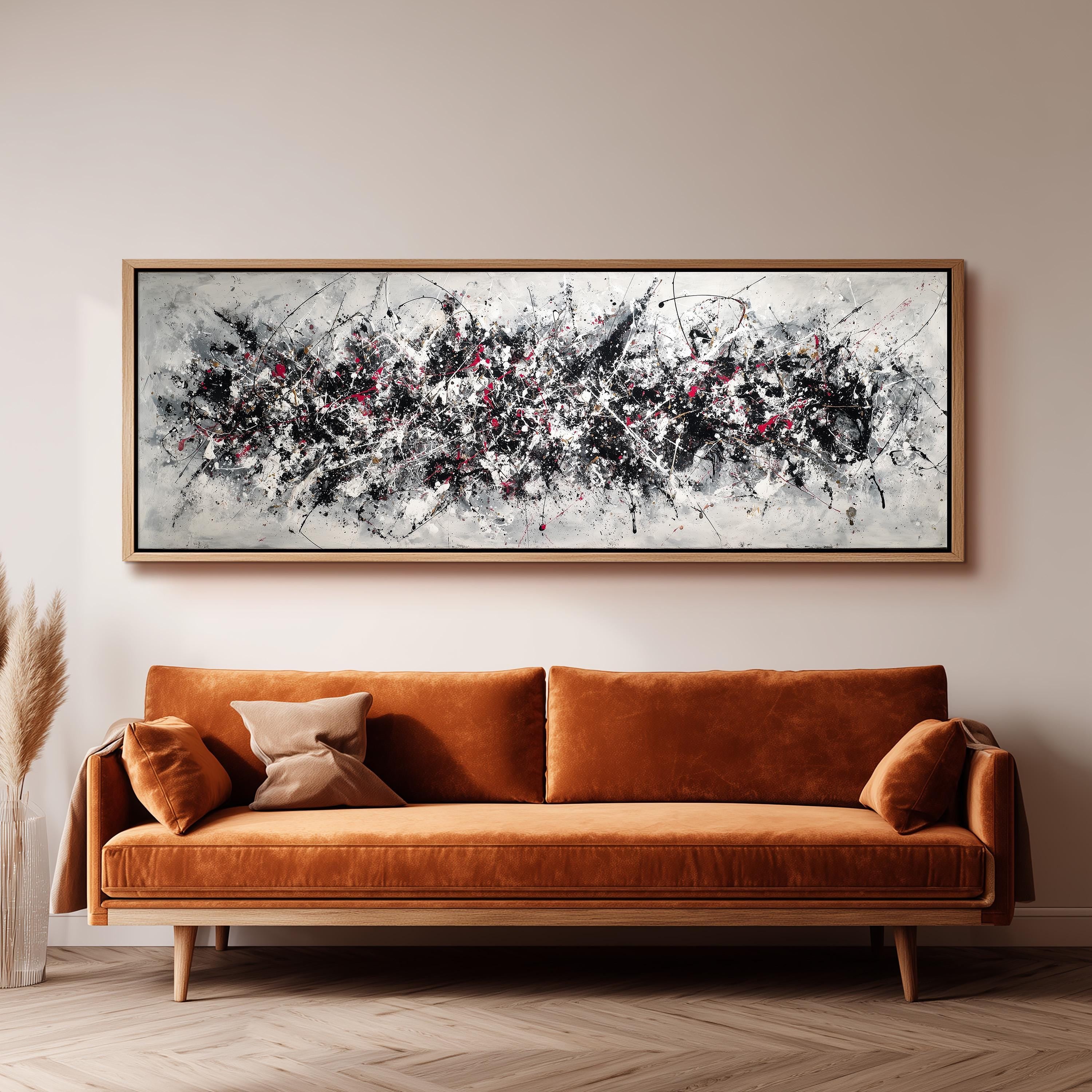a large abstract painting hanging on a wall above a brown sofa with orange cushions.