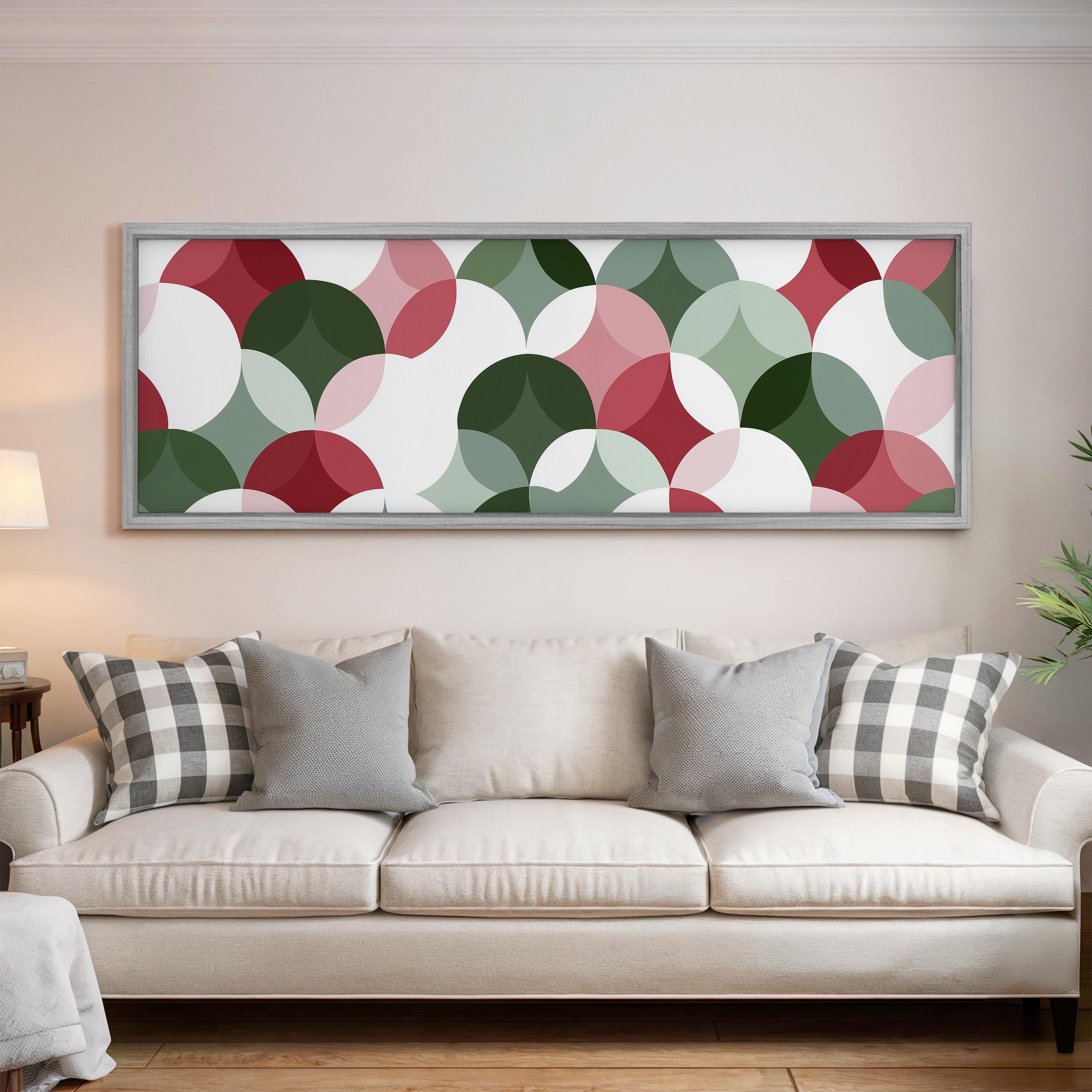 a large, colorful abstract painting hanging on a wall above a white couch with gray and black plaid throw pillows.