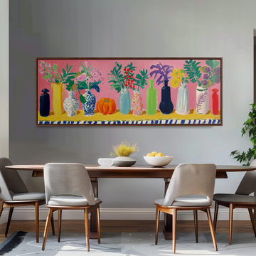 a dining room with a large painting of colorful vases and flowers hanging on the wall above a wooden dining table with four chairs.