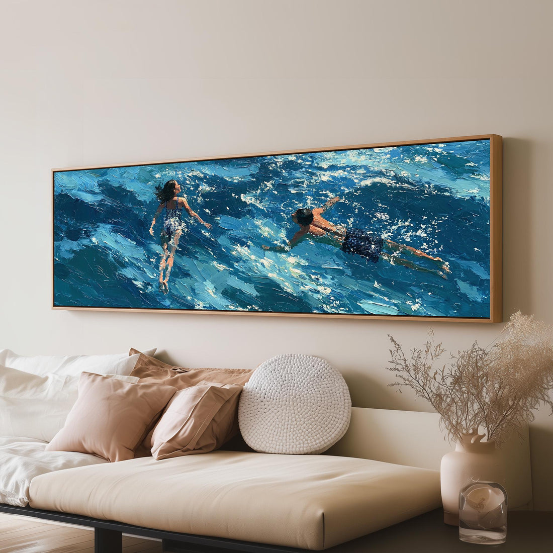 Two swimmers in turquoise waves long horizontal canvas print above a sofa in a living room