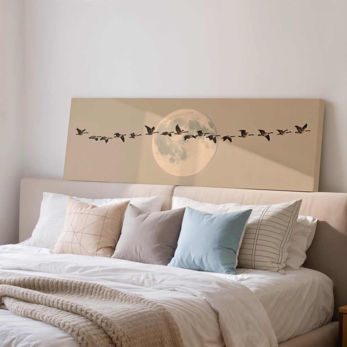 Geese flying across a pale moon on sand wide panoramic canvas print above a bed in a bedroom