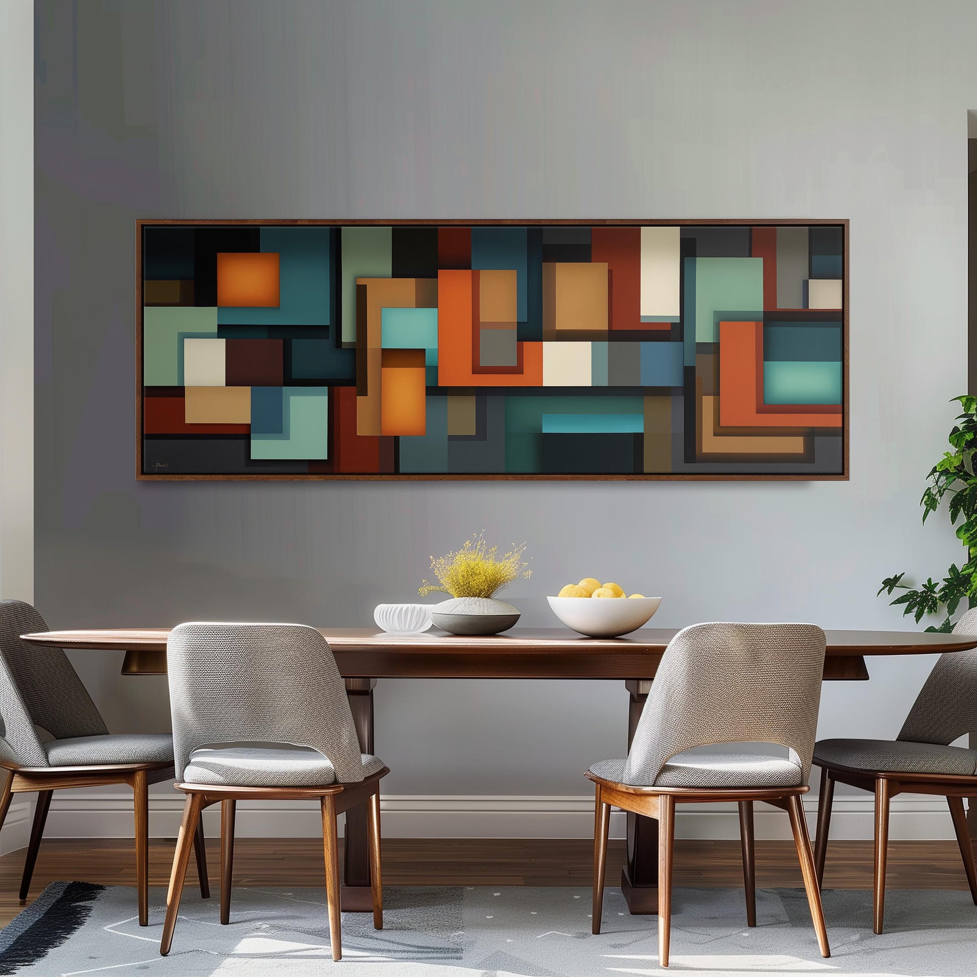 a modern dining room with a wooden table and four gray chairs. Above the table, there is a large abstract painting with various geometric shapes in different colors. On the table, there is a bowl of fruit and a vase of flowers.