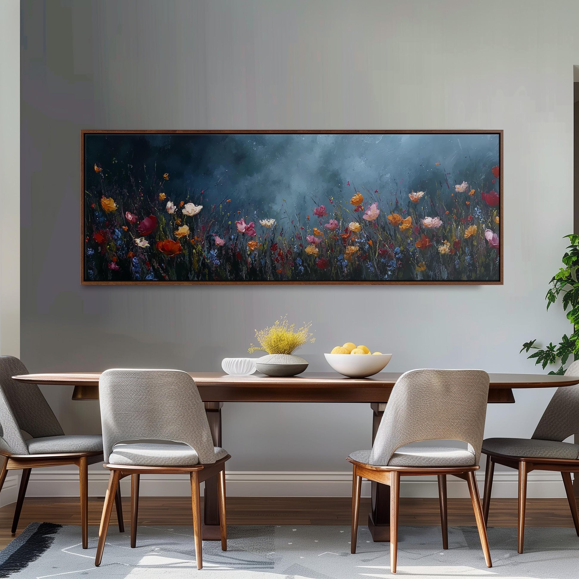 a dining room with a large painting of a field of flowers hanging on the wall above a wooden dining table with four chairs. The table is set with a bowl of fruit and a vase of flowers, creating a cozy and inviting atmosphere.