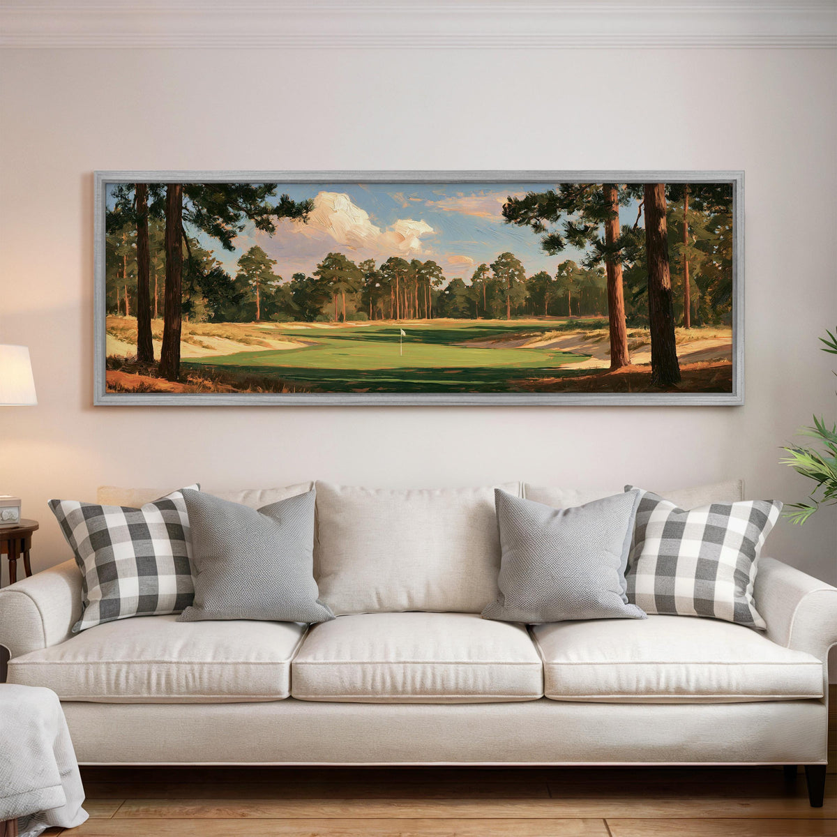 Golf fairway lined with tall pines panoramic canvas print above a white sofa in a bright living room