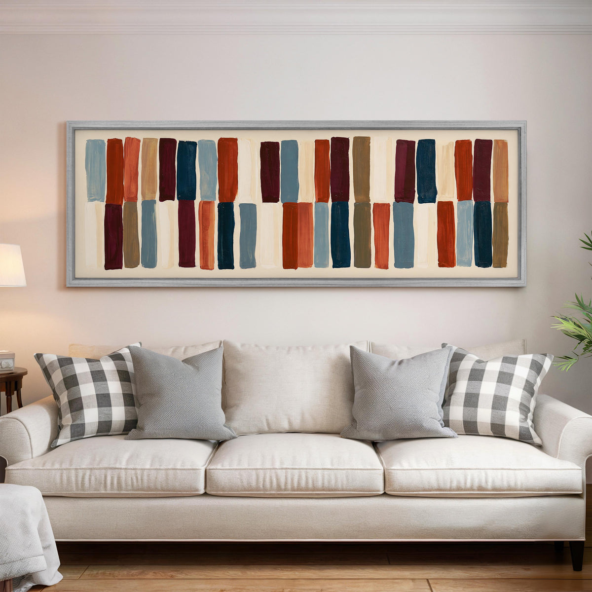Two tiers of staggered stripe blocks panoramic canvas print above a white sofa in a bright living room
