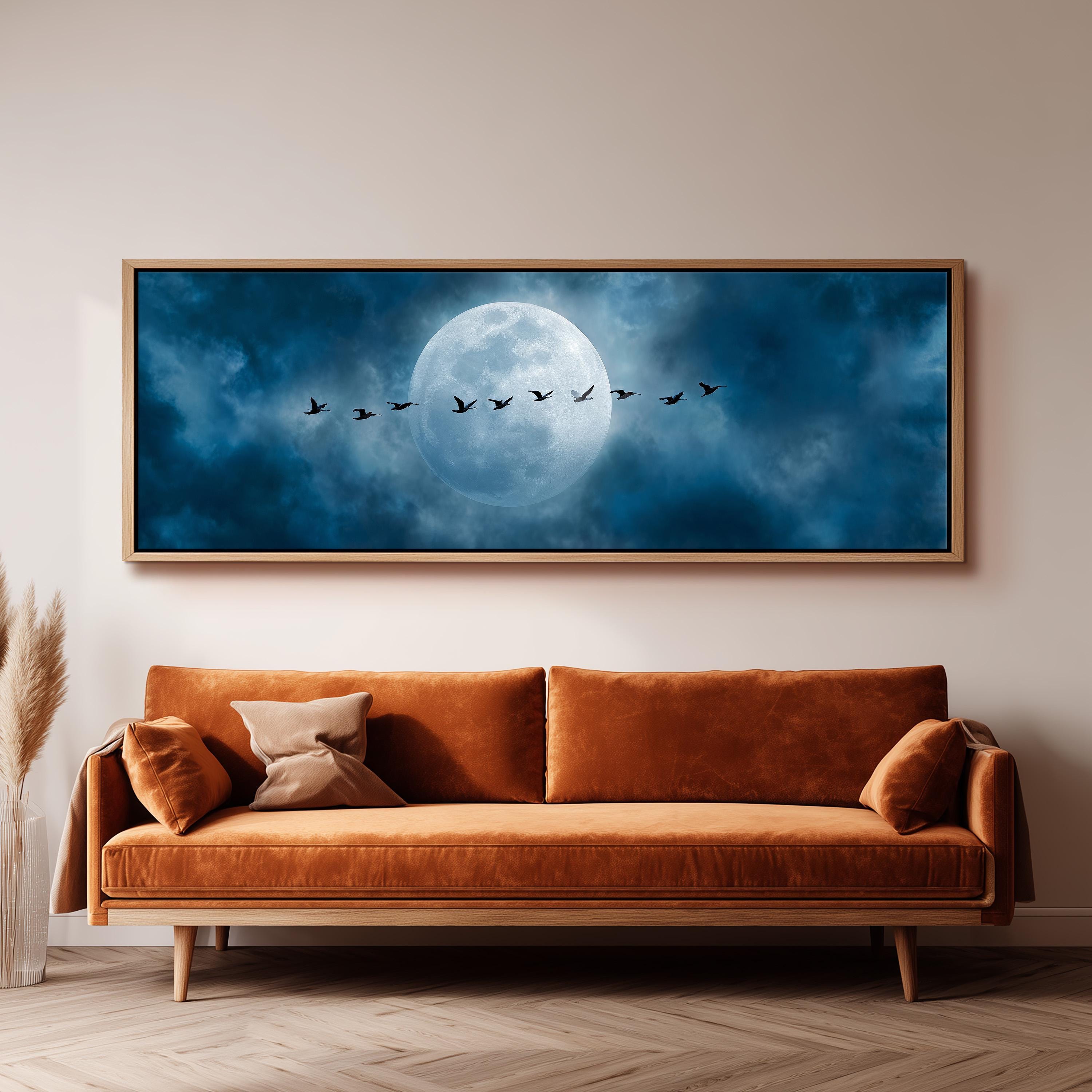 a large, framed painting of a flock of birds flying across a night sky with a full moon.